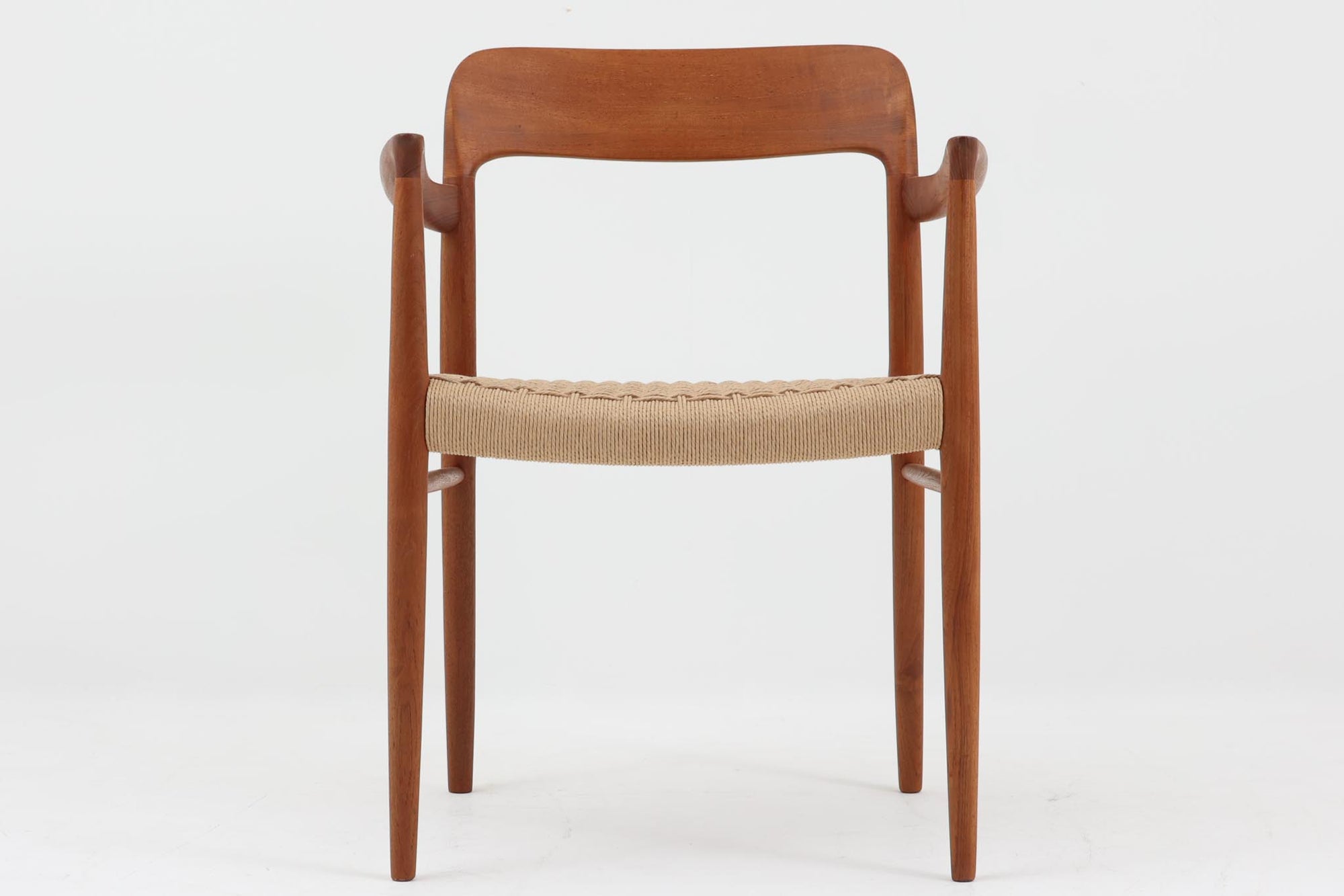北欧より買い付けたJ.L. moller社製のmodel 56アームチェアです。良質なチーク材が使用されており、厚みのあるチーク材が熟練の職人によって削り出されており、軽快な印象を受けます。座面にはペーパーコードが使用されており、自然で耐久性のある素材が特徴です。こちらのチェアはペーパーコードを張り替え済みのため、清潔で快適な状態でご使用いただけます。また、長く使用して座面が弱ってきた場合でも、張替えが可能なため、適切なメンテナンスを施すことで世代を超えてお使いいただける点も魅力です。現行品の販売もございますが、チーク材のフレームはビンテージ品でのみ入手可能であり、現在では希少な作品となっています。