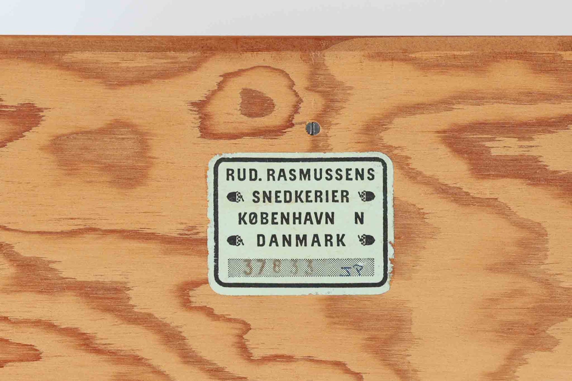 こちらは、1928年にmogens Kochによってデザインされた家具です。この家具には合板ではなく無垢材が使用されており、割れや狂いを防ぐためにさまざまな工夫が施されています。使用されているのは、良質で狂いが少ないパイン材の中でも、特に耐久性と強度に優れたオレゴンパインの無垢材が使用されています。経年変化によって深みを増した色味が魅力的な一点となっています。もともとは書斎用にデザインされたもので、扉付きキャビネットや奥行きの浅い棚など、好みに応じて組み合わせて使用できるシステムシェルフとして設計されています。そのため、ヴィンテージ家具市場では多様な組み合わせの形で見られることが特徴です。こちらの商品は、シンプルな台輪とシェルフ2点を組み合わせた構成となっています。