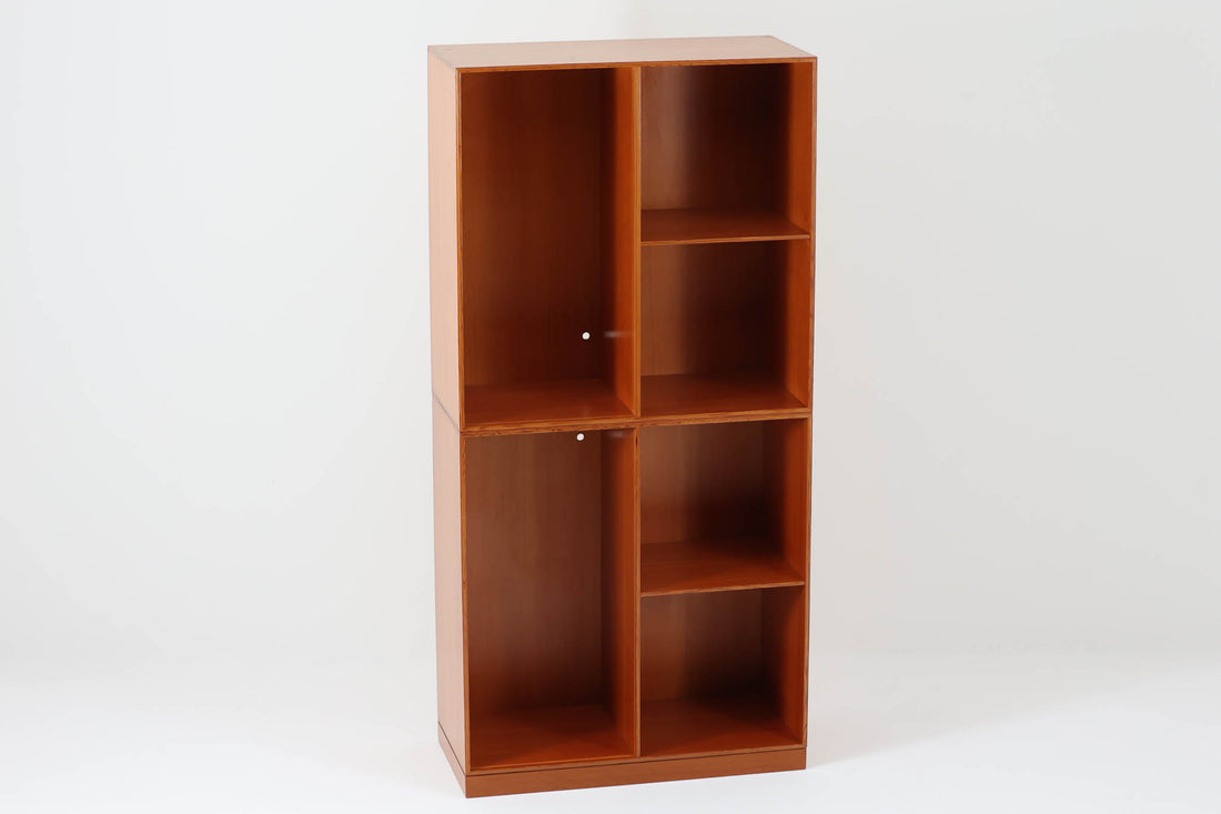 こちらは、1928年にmogens Kochによってデザインされた家具です。この家具には合板ではなく無垢材が使用されており、割れや狂いを防ぐためにさまざまな工夫が施されています。使用されているのは、良質で狂いが少ないパイン材の中でも、特に耐久性と強度に優れたオレゴンパインの無垢材が使用されています。経年変化によって深みを増した色味が魅力的な一点となっています。もともとは書斎用にデザインされたもので、扉付きキャビネットや奥行きの浅い棚など、好みに応じて組み合わせて使用できるシステムシェルフとして設計されています。そのため、ヴィンテージ家具市場では多様な組み合わせの形で見られることが特徴です。こちらの商品は、シンプルな台輪とシェルフ2点を組み合わせた構成となっています。
