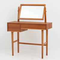 スウェーデン製の北欧ビンテージドレッサーで、チーク材とビーチ材を組み合わせた温かみある質感が魅力です。幅83cmとコンパクトながら、大小2杯の引き出しを備え、内部には仕切りもあり小物の整理に便利です。上部のミラーは角度調整が可能で、実用性と美観を兼ね備えています。直線的で軽快な脚部デザインが空間にすっきりとした印象を与え、経年による木肌の風合いが味わい深さを引き立てています。寝室や玄関先でも活躍する実用的かつ上品な一台です。