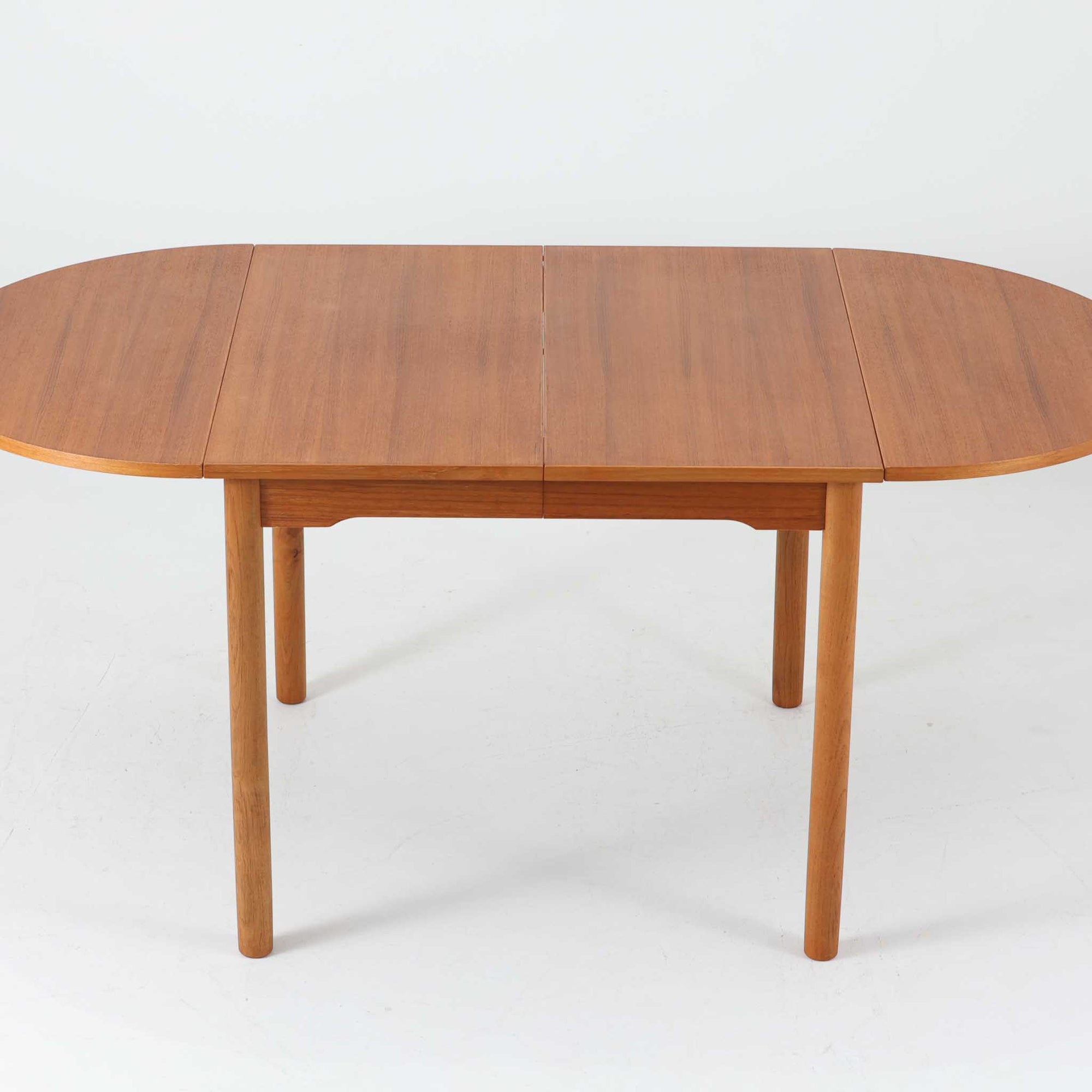 バタフライ式の半円天板と中央拡張板2枚を備えたエクステンションダイニングテーブルは、最大幅2520mmで8人でもゆったり囲めるサイズ感が魅力です。滑らかな金属レール構造により拡張もスムーズで、コンパクトな状態から広々とした食卓へ柔軟に変化します。温かみあるチーク材の質感と端正なデザインが調和した、北欧ビンテージ家具らしい実用性と美しさを兼ね備えた一台です。