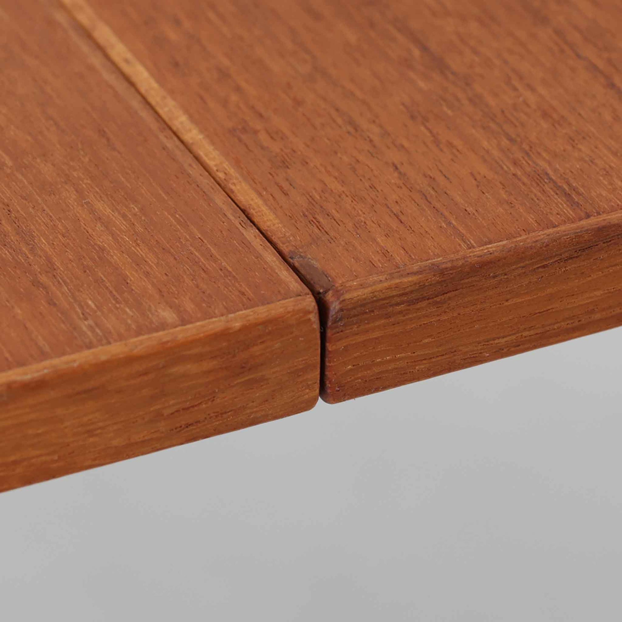 バタフライ式の半円天板と中央拡張板2枚を備えたエクステンションダイニングテーブルは、最大幅2520mmで8人でもゆったり囲めるサイズ感が魅力です。滑らかな金属レール構造により拡張もスムーズで、コンパクトな状態から広々とした食卓へ柔軟に変化します。温かみあるチーク材の質感と端正なデザインが調和した、北欧ビンテージ家具らしい実用性と美しさを兼ね備えた一台です。