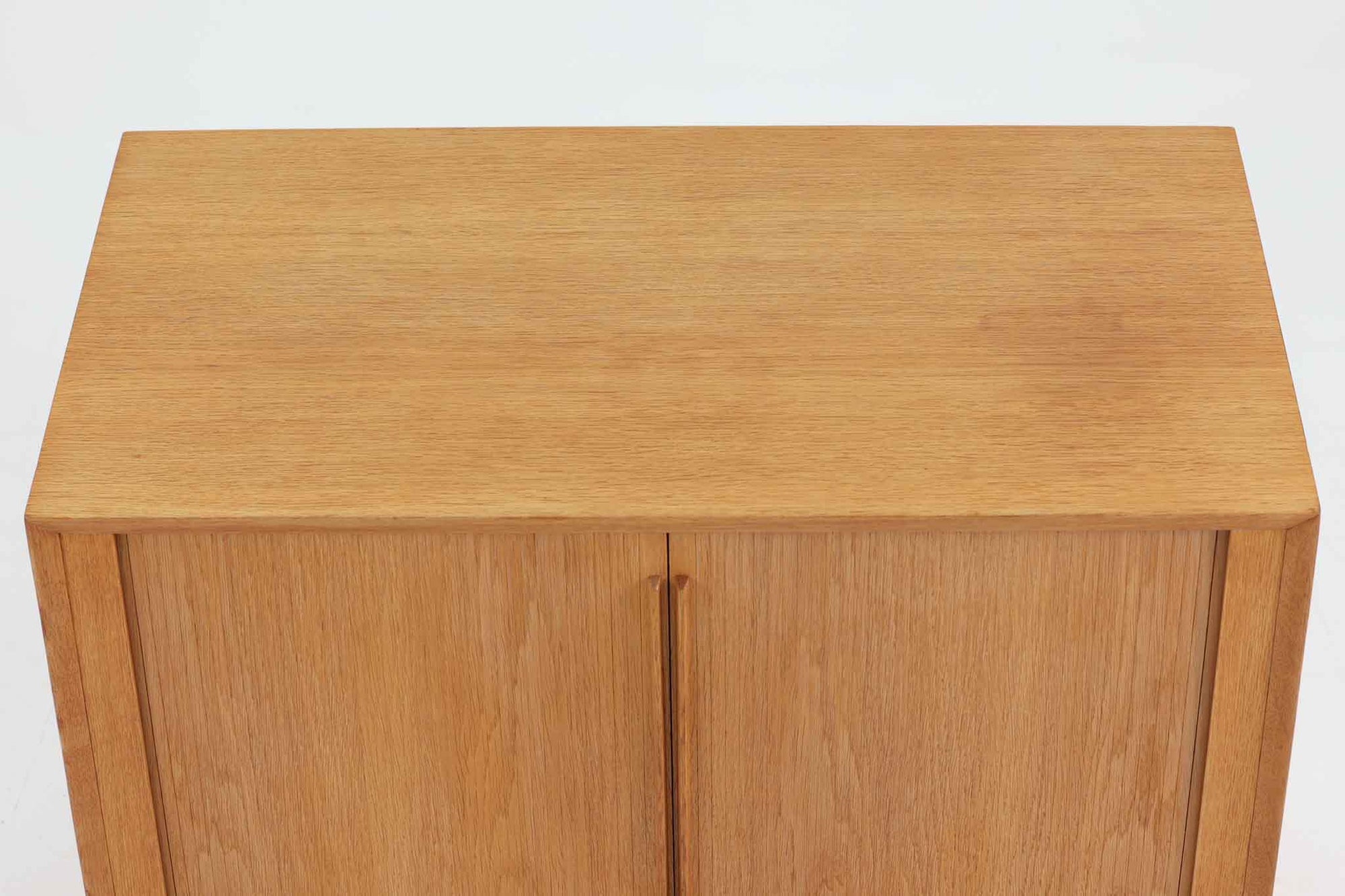 Hundevad &amp; Co社製の小ぶりな蛇腹キャビネットです。蛇腹式の扉を採用することで、扉が本体内部に収まり、内部の収納スペースを最大限に活用できます。また、引き出しが取り付けられており、機能性も兼ね備えています。本体には高品質なオーク材が使用されており、堅牢さと美しさが際立っています。