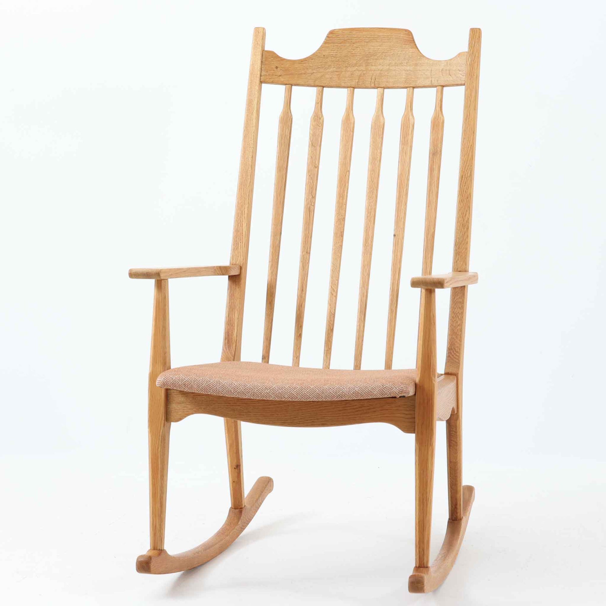 デンマークのデザイナーHenning Kjaernulf（ヘニング・ケアヌルフ）によるロッキングチェアは、EG Mobler社によって製造された美しい造形と機能性を兼ね備えた北欧ビンテージ家具です。背もたれのスピンドル構造と高めに設計されたヘッドレストが、身体をやさしく包み込み、心地よい揺れとともにくつろぎの時間を提供します。上質なオーク材を使用したフレームは、経年とともに味わいを増し、温かみのある木肌が空間に落ち着きと品格を与えてくれます。シンプルでありながらも、クラフトマンシップが随所に感じられる一脚で、リビングや読書スペース、窓辺のくつろぎ空間に最適です。