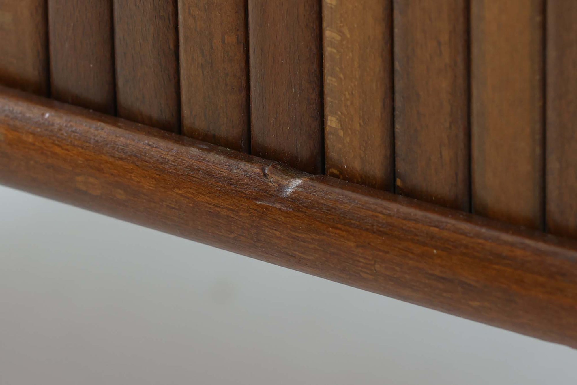 北欧デンマークで製造された、蛇腹扉が特徴的なビンテージキャビネットです。素材にはビーチ材と思われる無垢材や突板が使用されており、ステイン塗装により落ち着いたブラウンカラーに仕上げられています。前面には細かな縦ラインが連続する蛇腹扉が配され、開閉時に滑らかに動く美しい構造が魅力です。内部には棚板が一枚付属しており、収納としての機能性も十分です。丸脚や小さな丸い取っ手も北欧らしい柔らかなディテールで、リビングや玄関、寝室などさまざまな空間に自然に溶け込む一台です。