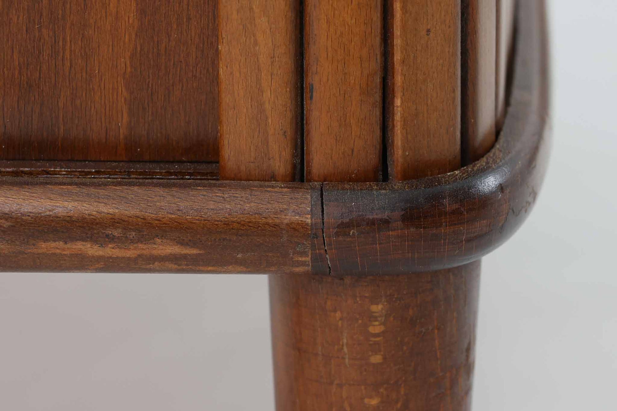 北欧デンマークで製造された、蛇腹扉が特徴的なビンテージキャビネットです。素材にはビーチ材と思われる無垢材や突板が使用されており、ステイン塗装により落ち着いたブラウンカラーに仕上げられています。前面には細かな縦ラインが連続する蛇腹扉が配され、開閉時に滑らかに動く美しい構造が魅力です。内部には棚板が一枚付属しており、収納としての機能性も十分です。丸脚や小さな丸い取っ手も北欧らしい柔らかなディテールで、リビングや玄関、寝室などさまざまな空間に自然に溶け込む一台です。