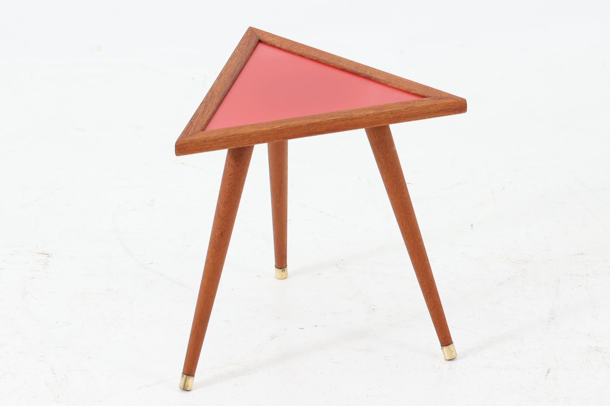 北欧より買い付けたサイドテーブルです。レッド色のシートが張られた天板と、3本脚のチーク材との組み合わせが美しい一品で、プランターテーブルとしてもご利用いただけます。ゴールド色の脚先がデザインのアクセントとなっています。