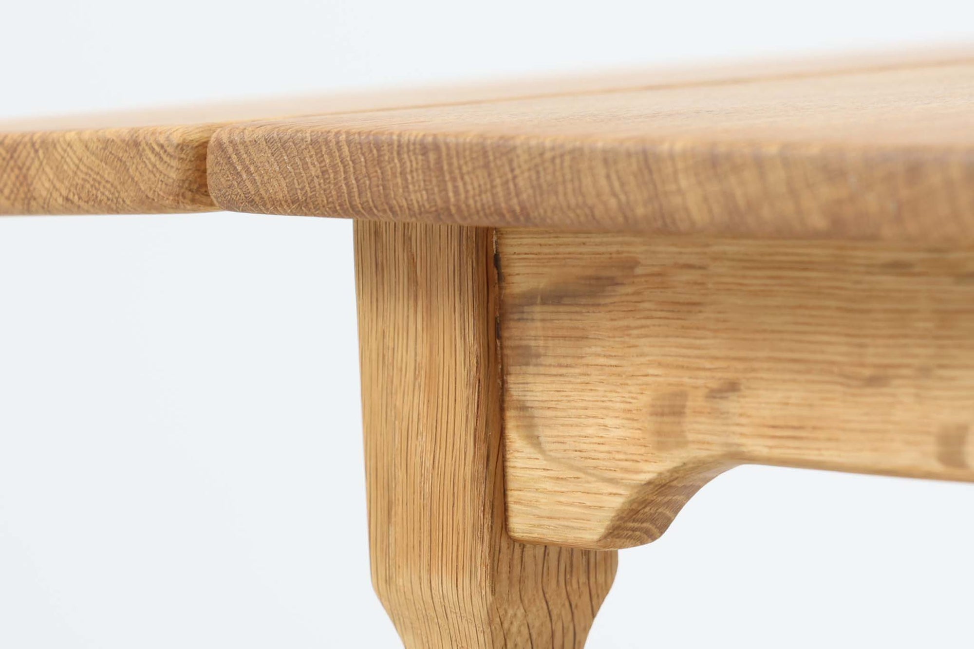 デンマークの建築家Henning Kjaernulf（ヘニング・ケアヌルフ）によってデザインされた、オーク無垢材のドロップリーフ式センターテーブルです。製造は高品質な家具で知られるEGモブラー社。無垢材ならではの美しい木目と、クラシカルで彫刻的な脚部のラインが印象的です。天板は両側に開閉式のリーフが備わっており、来客時や作業時には広げてスペースを拡張できるなど、実用性も兼ね備えています。高さ約51cmとやや高めの設計で、ソファ前に置いても手元が使いやすく、センターテーブルとして快適にお使いいただけます。必要に応じてサイドテーブルやティーテーブルとしても活躍する、用途の広い一台です。