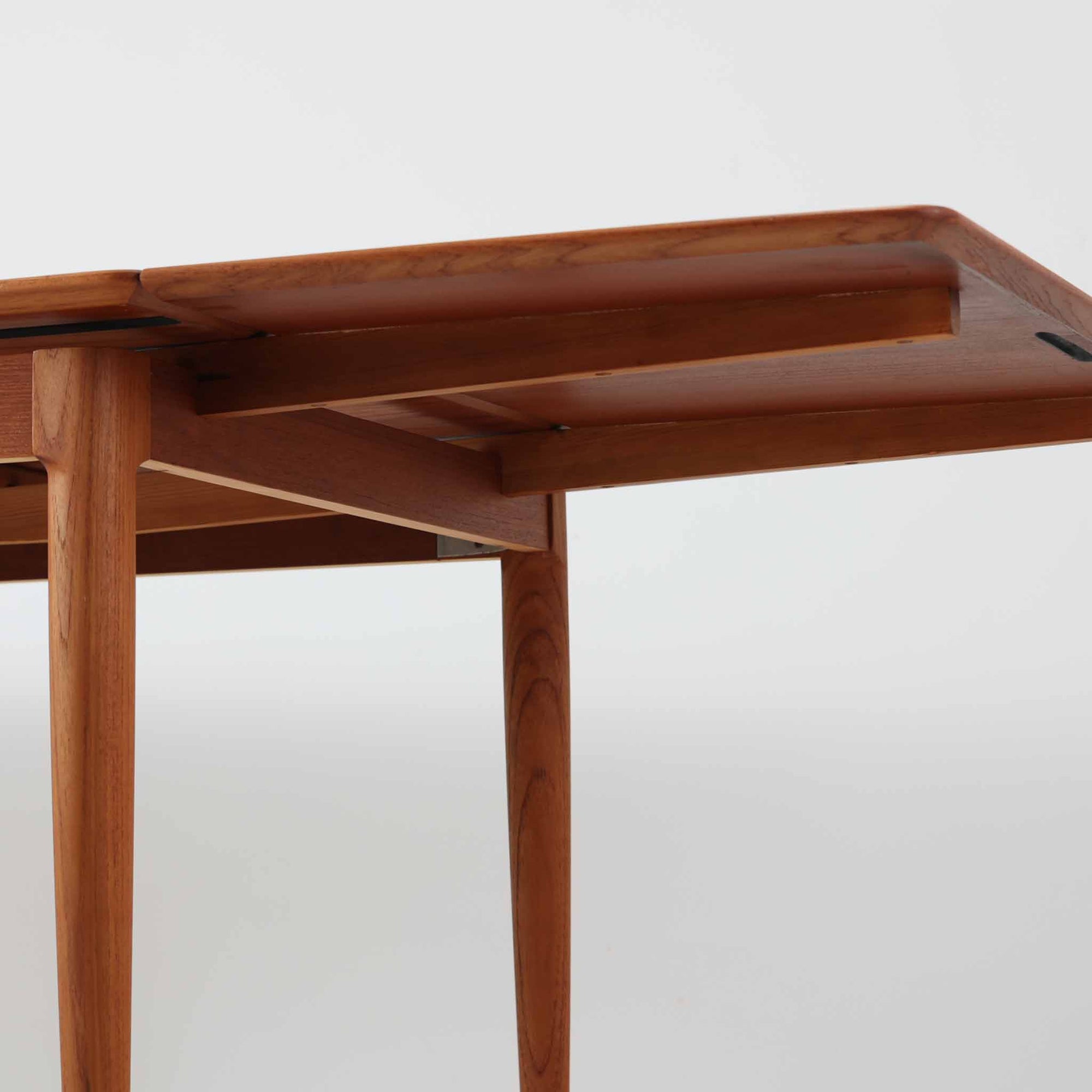 チーク材の温かみある風合いと洗練されたシルエットが魅力のエクステンションダイニングテーブルです。デザイナーは不明ですが、脚部や拡張板の形状など、細部にまでこだわりが感じられる上質な一品です。