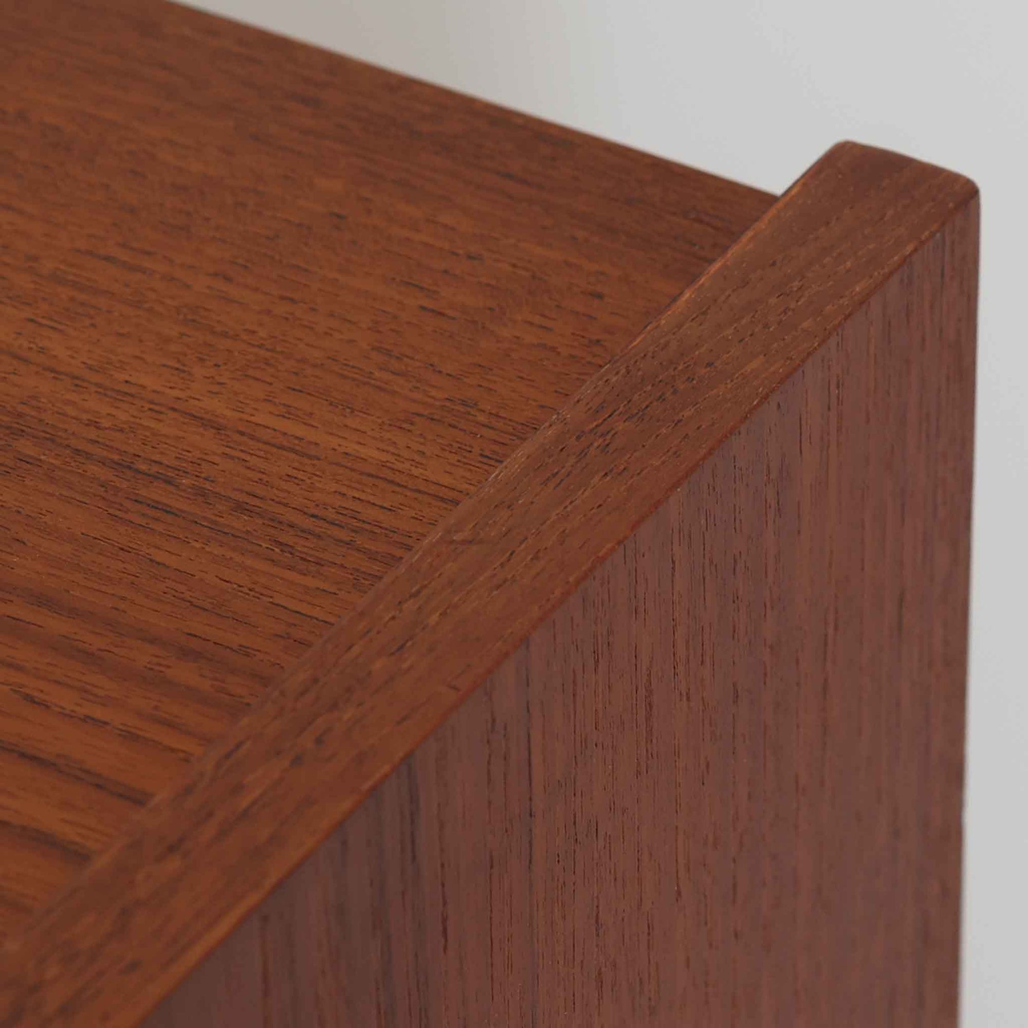 デンマーク製ライティングビューロです。上段には3杯の小引き出しとオープンスペースを備え、文具や手紙などを整理しながら使える実用的な設計です。丸い意匠の取っ手や滑らかな脚部のラインが北欧らしい温かみを感じさせ、チーク材の艶やかな木目が上品な印象を与えます。天板を開くと小さな書斎のような空間が広がり、リビングや寝室でも場所を取らず快適に作業が可能です。下段には3杯の引き出しを配置し、書類やノート類もしっかり収納できます。細身の脚部が軽やかさを添え、省スペースながら十分な収納力を兼ね備えた機能美あふれる一台です。経年によって増した風合いが魅力の、上質な北欧ビンテージ家具です。