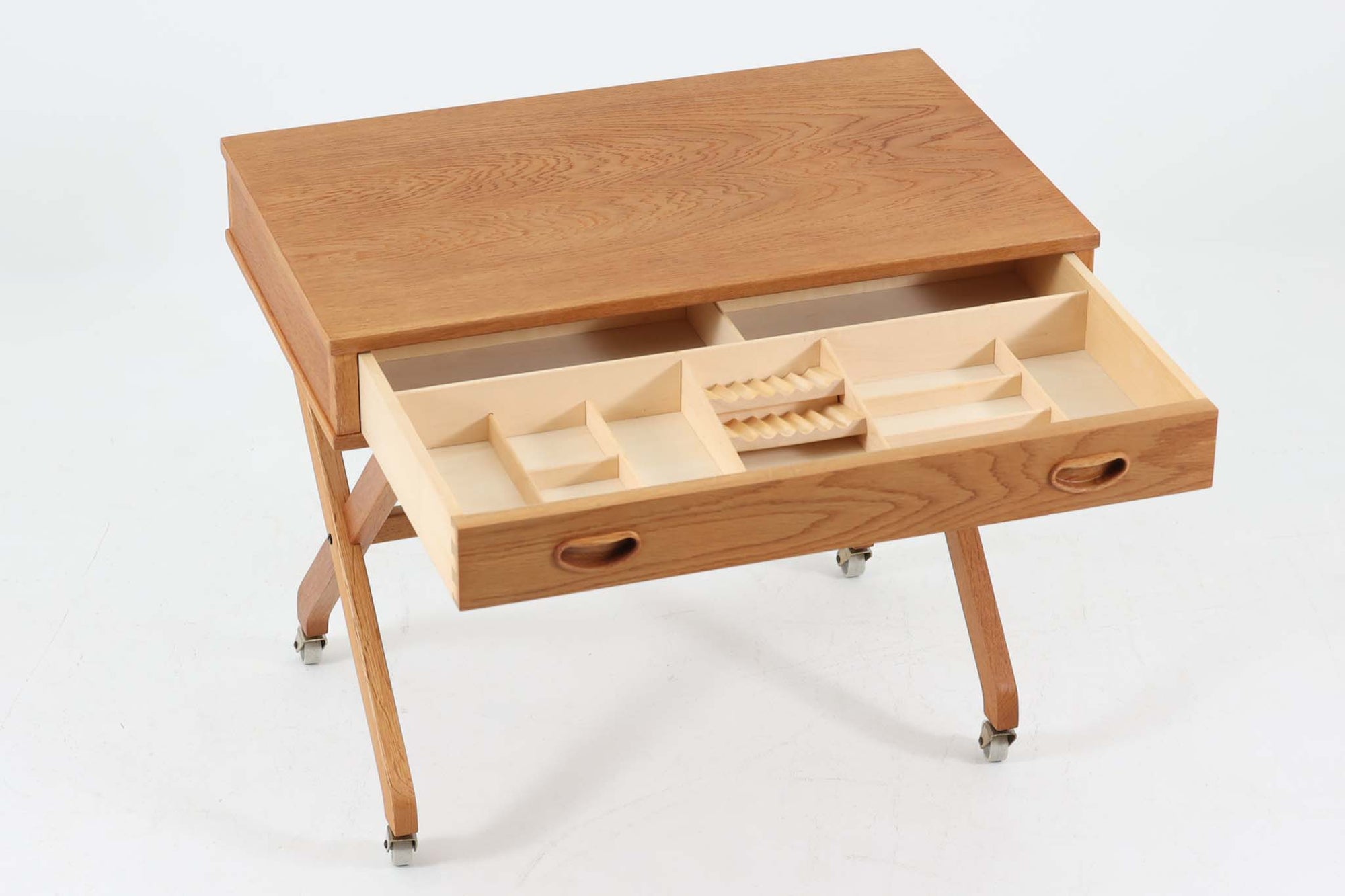 デンマーク製のビンテージ・ソーイングテーブルです。天板下には大きな引き出しが備わっており、裁縫道具や小物を収納するのに最適です。また、中央には籐製のバスケットが付属しており、毛糸や生地などを入れるのに便利な作りとなっています。脚部は交差したデザインが特徴的で、軽やかな印象を与えます。キャスター付きのため移動もスムーズで、リビングやワークスペースなどさまざまな場所で活躍します。シンプルながらも温かみのあるデザインは、北欧家具ならではの魅力。ソーイングテーブルとしてはもちろん、サイドテーブルとしてもお使いいただけます。