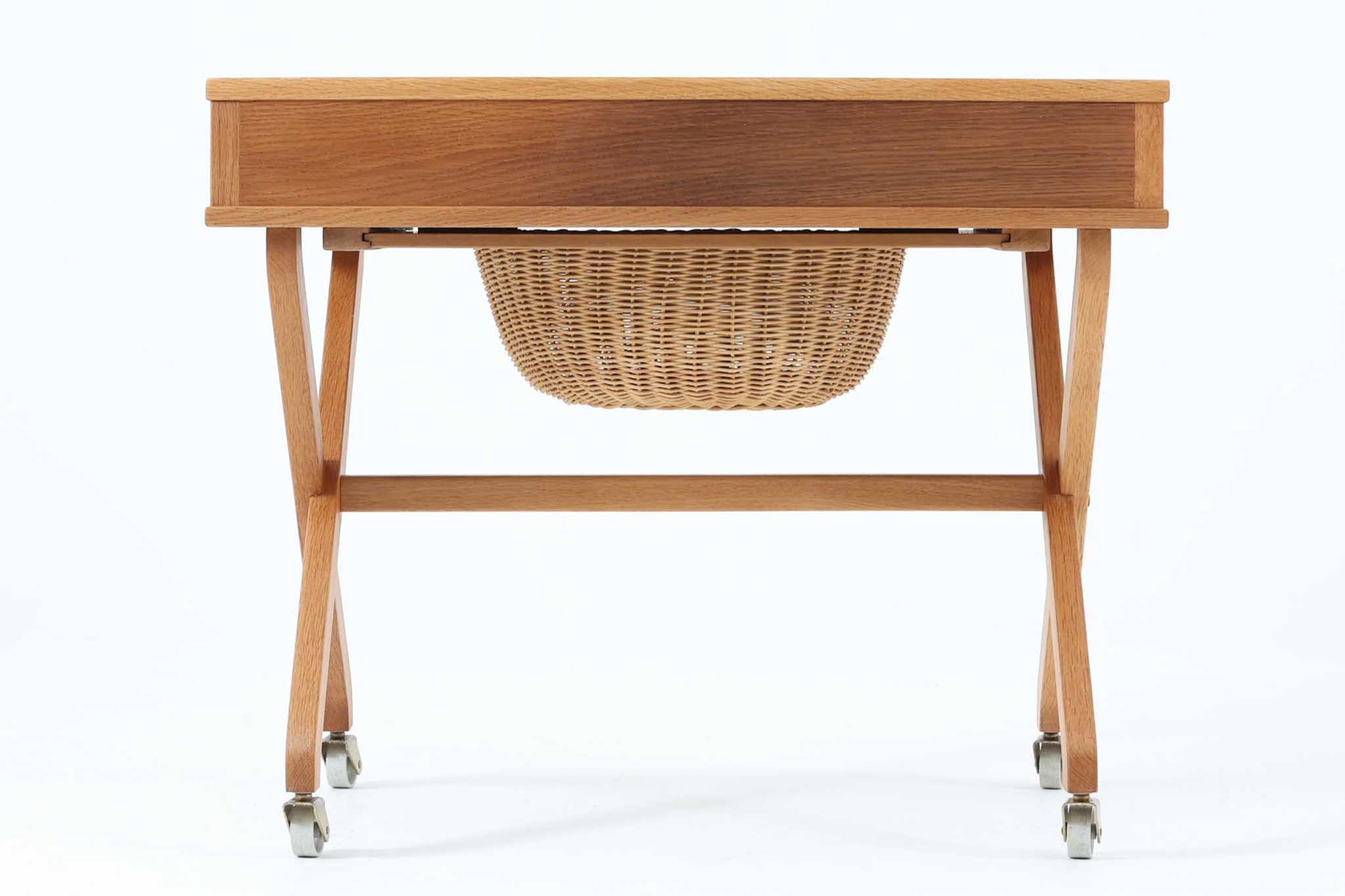 デンマーク製のビンテージ・ソーイングテーブルです。天板下には大きな引き出しが備わっており、裁縫道具や小物を収納するのに最適です。また、中央には籐製のバスケットが付属しており、毛糸や生地などを入れるのに便利な作りとなっています。脚部は交差したデザインが特徴的で、軽やかな印象を与えます。キャスター付きのため移動もスムーズで、リビングやワークスペースなどさまざまな場所で活躍します。シンプルながらも温かみのあるデザインは、北欧家具ならではの魅力。ソーイングテーブルとしてはもちろん、サイドテーブルとしてもお使いいただけます。