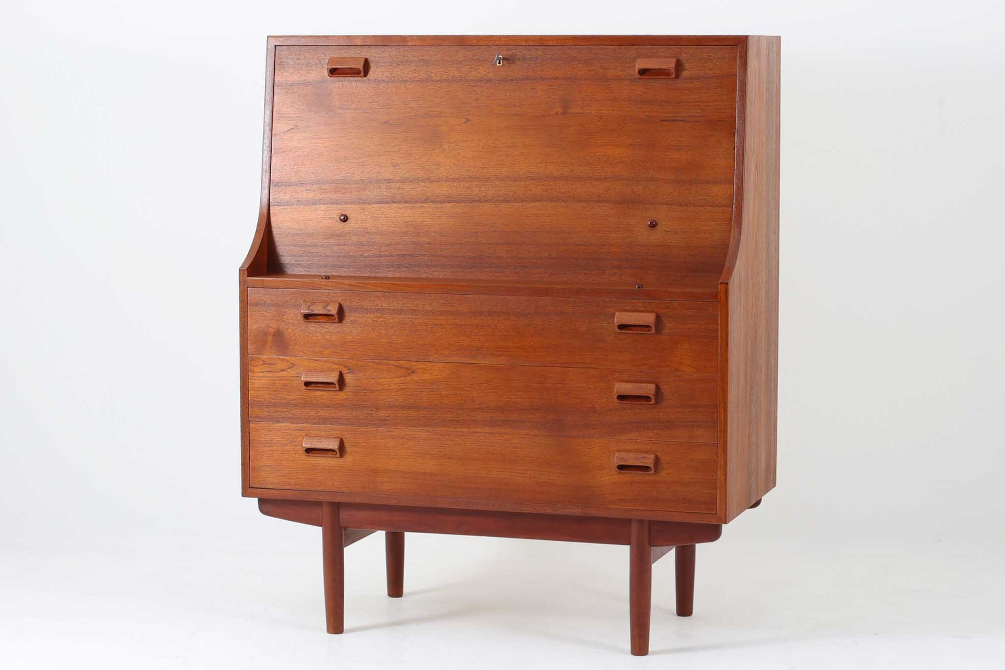 デンマークを代表する家具デザイナー、Børge mogensen（ボーエ・モーエンセン）が手がけた、Soborg mobler社製のビンテージライティングビューロです。落ち着きのある深い色味と美しい木目が特徴的なチーク材を贅沢に使用しており、北欧ミッドセンチュリーらしい温かみと洗練された雰囲気を兼ね備えています。上部のライティングスペースには、2杯の小引き出しと仕切り棚が設けられており、文房具や書類の整理にも最適。天板は折りたたみ式で、コンパクトに収納しつつも、必要に応じてしっかりとした作業スペースとしてお使いいただけます。下部にはフルサイズの引き出しが3杯あり、収納力にも優れています。脚部のデザインも軽やかで、空間に圧迫感を与えません。リビングやワークスペースに、実用性と美しさを兼ね備えた一台としておすすめです。