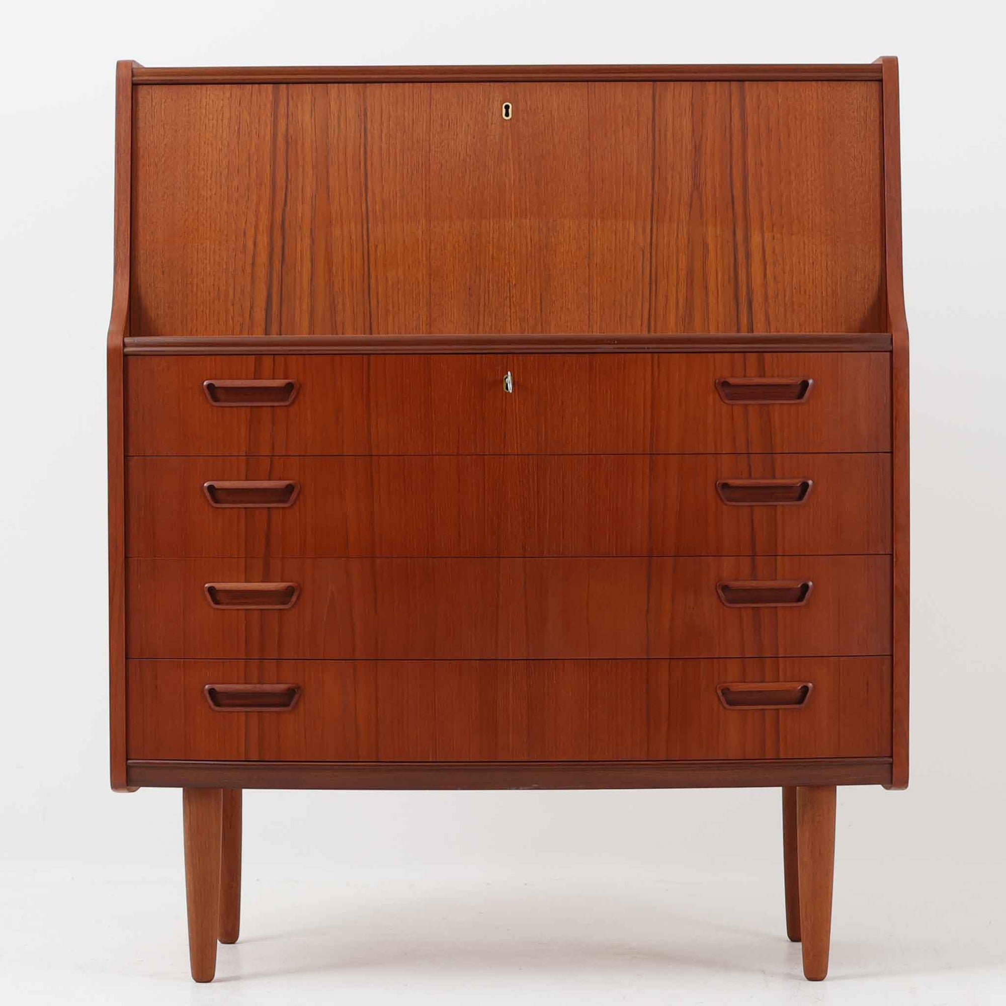 Poul M.Jessenによるこちらのライティングビューロは、PMJ Viby社製の北欧ビンテージ家具で、美しい木目のチーク材を用いた上品な佇まいが魅力です。緩やかにカーブした側面や繊細な取手の意匠、引き出しと小さな収納棚を備えたライティングスペースなど、機能性とデザイン性が見事に調和しています。幅92cmの程よいサイズ感で、リビングや寝室のデスク兼収納としても活躍し、空間に静かな存在感を添える一台です。