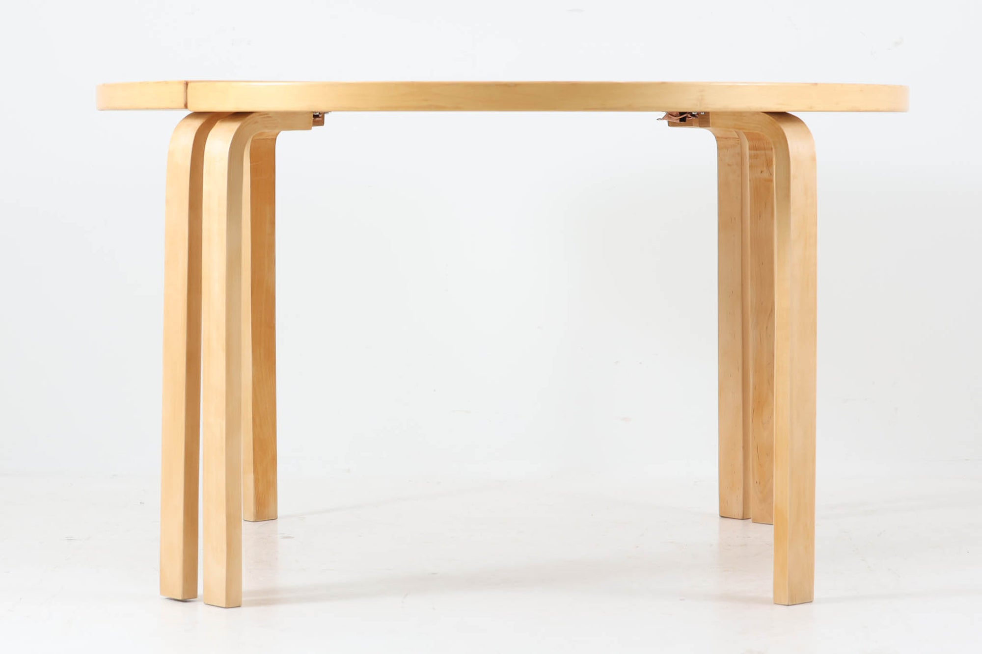 北欧で買い付けたアアルトデザインのヴィンテージテーブル「95」のご紹介です。元オーナーは、2つの半円テーブルを連結金具で組み合わせ、円形のダイニングテーブルとして使用していました。半円テーブルとしても、壁に沿わせてお使いいただけますが、連結金具が少し出るため、壁面に若干の隙間が生じる場合があります。円形での使用予定がない場合、連結金具を取り外してシンプルな半円タイプとしてご利用ください。こちらは半円タイプ「95」2点セットでの販売です。天板には、経年変化が楽しめるリノリウム素材が使用されています。