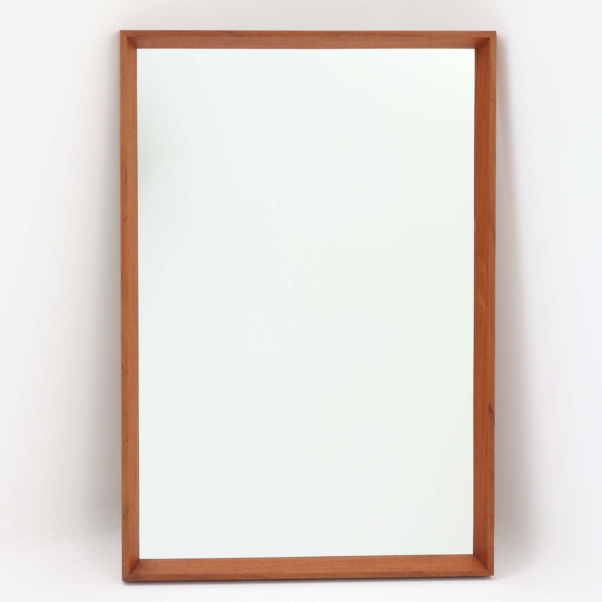 シンプルでありながらもチーク材の豊かな表情が際立つこちらの壁掛け/立掛けミラーは、北欧ビンテージ家具ならではの丁寧な造りと温もりを感じさせる一品です。直線的で無駄のないフレームデザインは、空間に自然と溶け込みつつも上質な印象を与えます。縦長フォルムで姿見としても使いやすく、玄関や寝室、リビングなど様々な場所に設置可能。背面には壁掛け用の金具も付属しており、用途やスタイルに合わせて自在に活用できるのも魅力です。