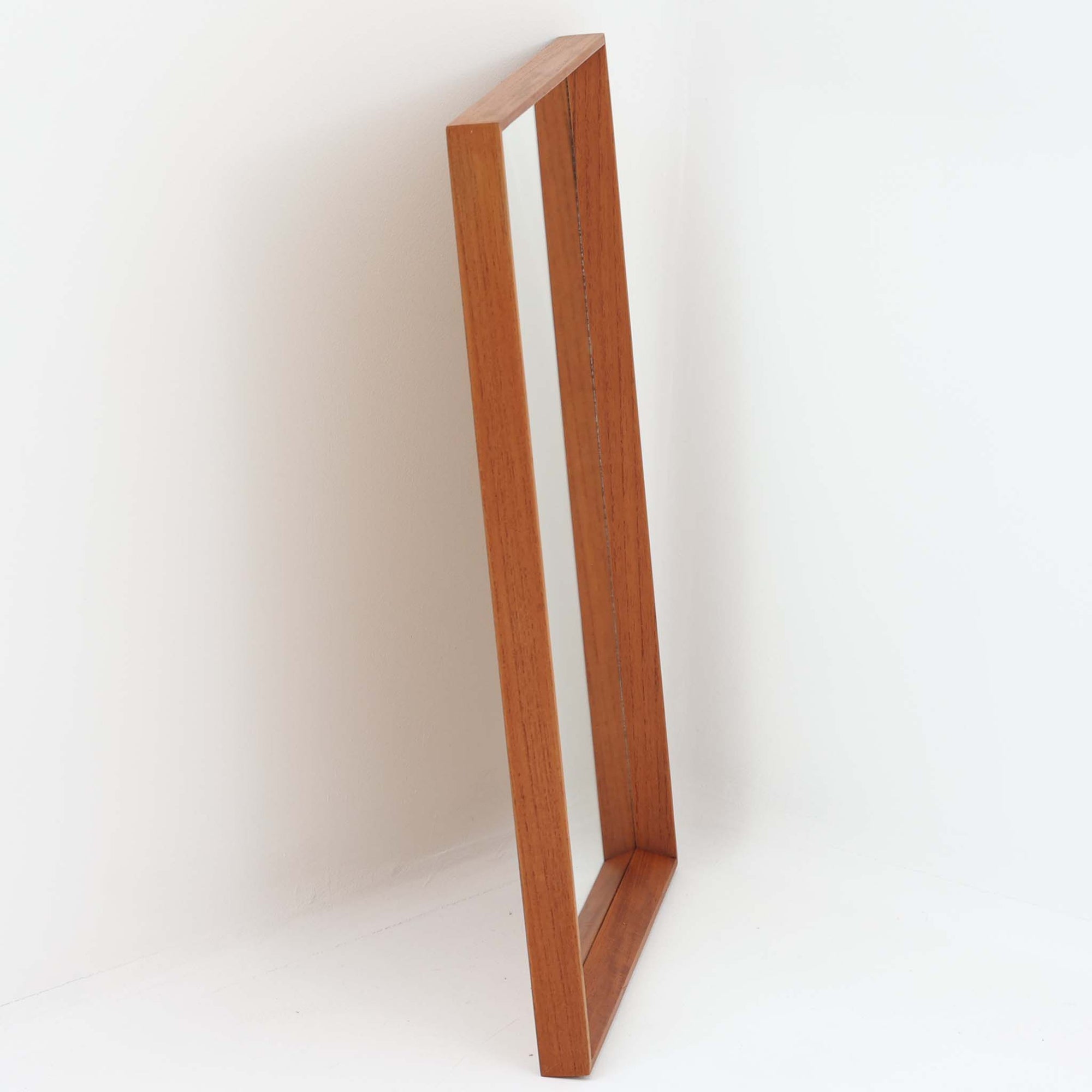 シンプルでありながらもチーク材の豊かな表情が際立つこちらの壁掛け/立掛けミラーは、北欧ビンテージ家具ならではの丁寧な造りと温もりを感じさせる一品です。直線的で無駄のないフレームデザインは、空間に自然と溶け込みつつも上質な印象を与えます。縦長フォルムで姿見としても使いやすく、玄関や寝室、リビングなど様々な場所に設置可能。背面には壁掛け用の金具も付属しており、用途やスタイルに合わせて自在に活用できるのも魅力です。