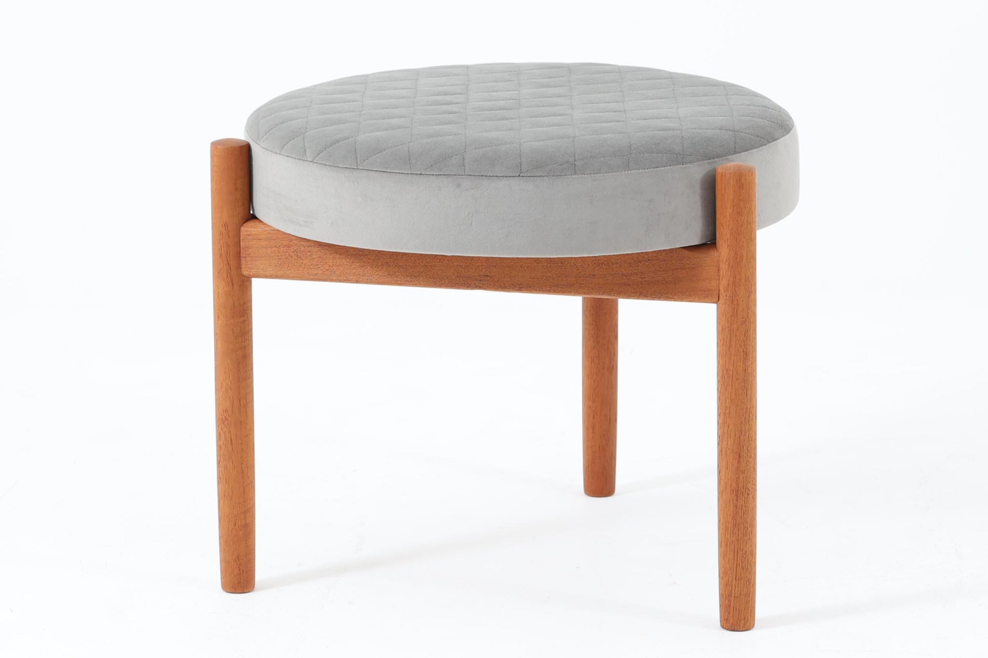 デンマークのデザイナー Hugo Frandsen によるビンテージスツールです。フレームにはチーク材が使用され、丸みを帯びたフォルムが優雅な印象を与えます。座面は上質なファブリックで張り替えられており、キルティングのディテールが上品なアクセントになっています。適度なクッション性があり、快適な座り心地を提供します。3本脚のデザインがこのスツールの大きな特徴 です。三脚構造は、視覚的なバランスが美しく、すっきりとした印象を与えるだけでなく、凹凸のある床面でも安定しやすいという利点があります。北欧家具に見られる機能美を感じられる一脚です。コンパクトなサイズ感で、ダイニングチェアの補助としてはもちろん、玄関やベッドサイド、リビングのサイドテーブルとしても活躍します。