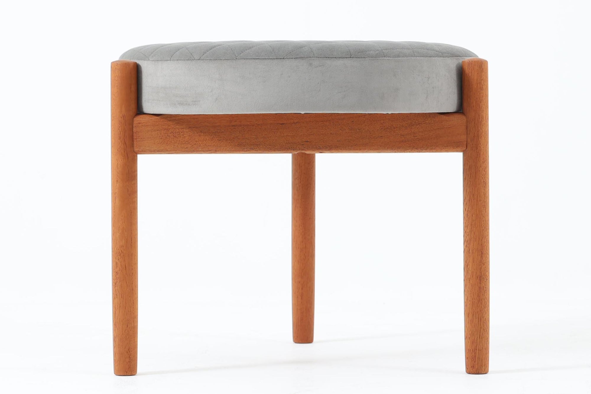 デンマークのデザイナー Hugo Frandsen によるビンテージスツールです。フレームにはチーク材が使用され、丸みを帯びたフォルムが優雅な印象を与えます。座面は上質なファブリックで張り替えられており、キルティングのディテールが上品なアクセントになっています。適度なクッション性があり、快適な座り心地を提供します。3本脚のデザインがこのスツールの大きな特徴 です。三脚構造は、視覚的なバランスが美しく、すっきりとした印象を与えるだけでなく、凹凸のある床面でも安定しやすいという利点があります。北欧家具に見られる機能美を感じられる一脚です。コンパクトなサイズ感で、ダイニングチェアの補助としてはもちろん、玄関やベッドサイド、リビングのサイドテーブルとしても活躍します。