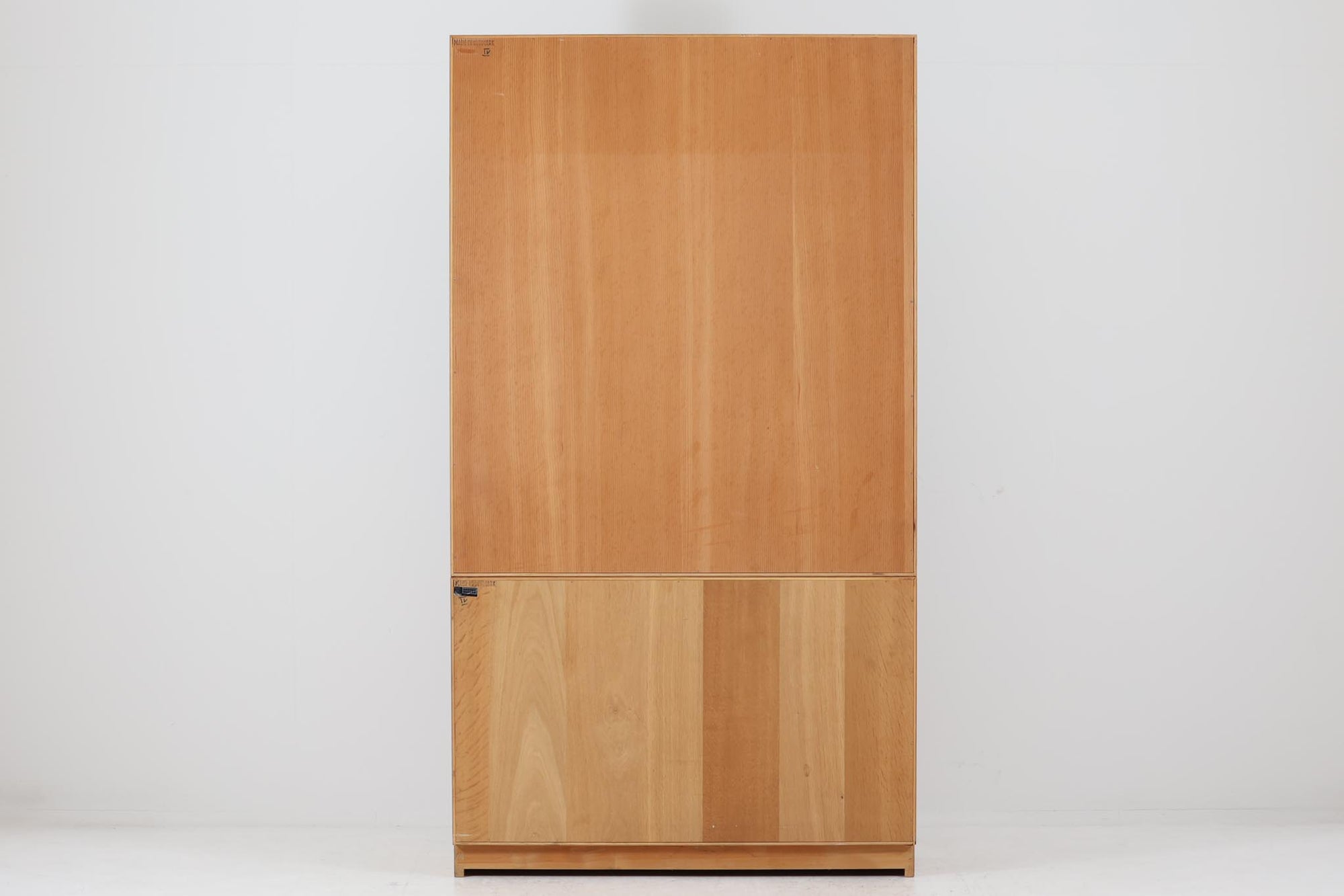 デンマークの名工Soborg社によって製作されたディスプレイシェルフです。下段部分にはキャビネット、上段部分には小ぶりな棚が重ねられたシンプルで洗練されたデザインが特徴です。通常、上段と下段の奥行きが異なるものが多い中、こちらは上下ともにフラットな作りとなっており、すっきりとした印象を与えます。本体には上質なオーク材が使用され、モーエンセンらしい独特のキャビネットの取手がアクセントとなったデザインが魅力です。