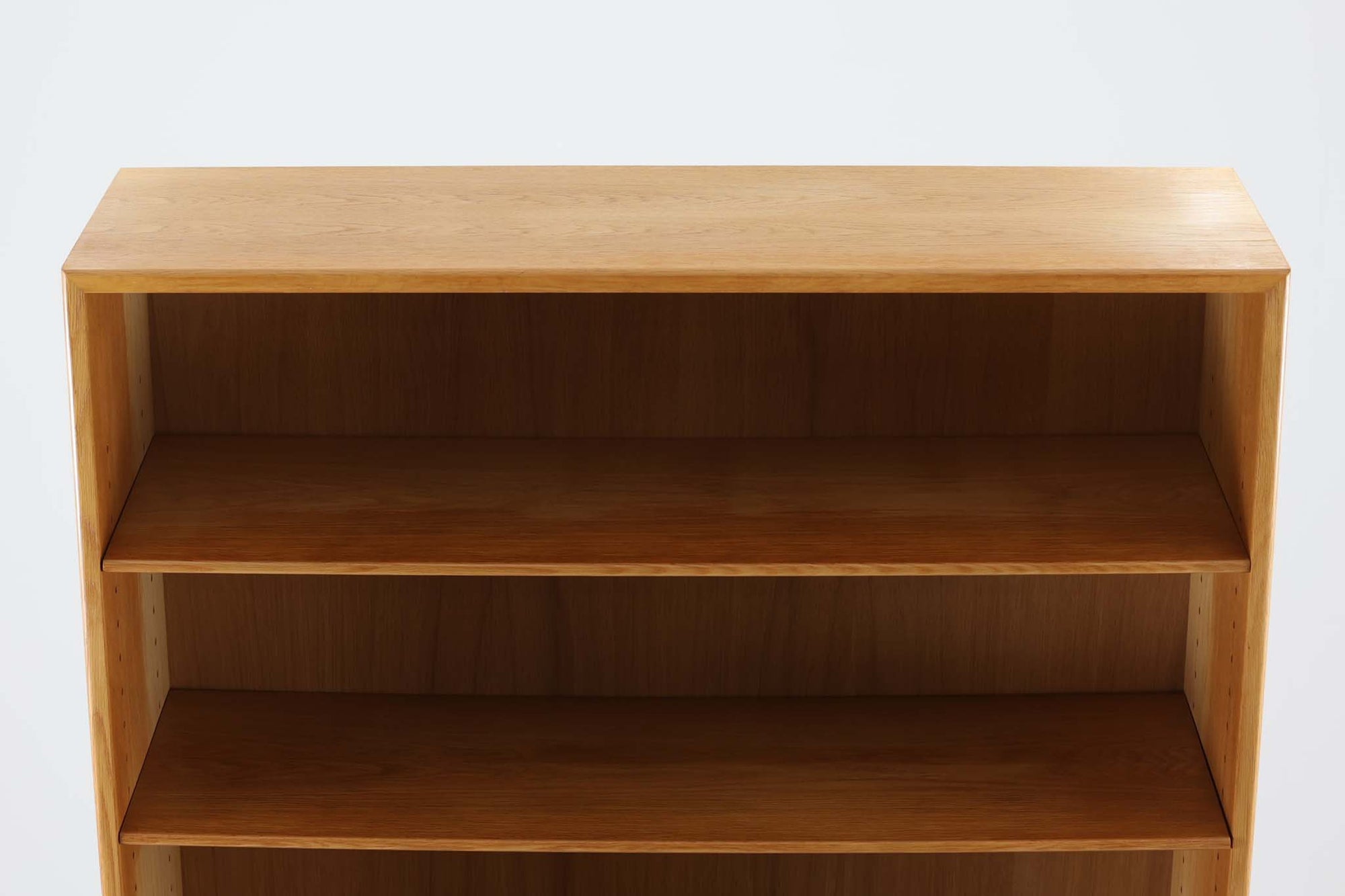 デンマークの名工Soborg社によって製作されたディスプレイシェルフです。下段部分にはキャビネット、上段部分には小ぶりな棚が重ねられたシンプルで洗練されたデザインが特徴です。通常、上段と下段の奥行きが異なるものが多い中、こちらは上下ともにフラットな作りとなっており、すっきりとした印象を与えます。本体には上質なオーク材が使用され、モーエンセンらしい独特のキャビネットの取手がアクセントとなったデザインが魅力です。