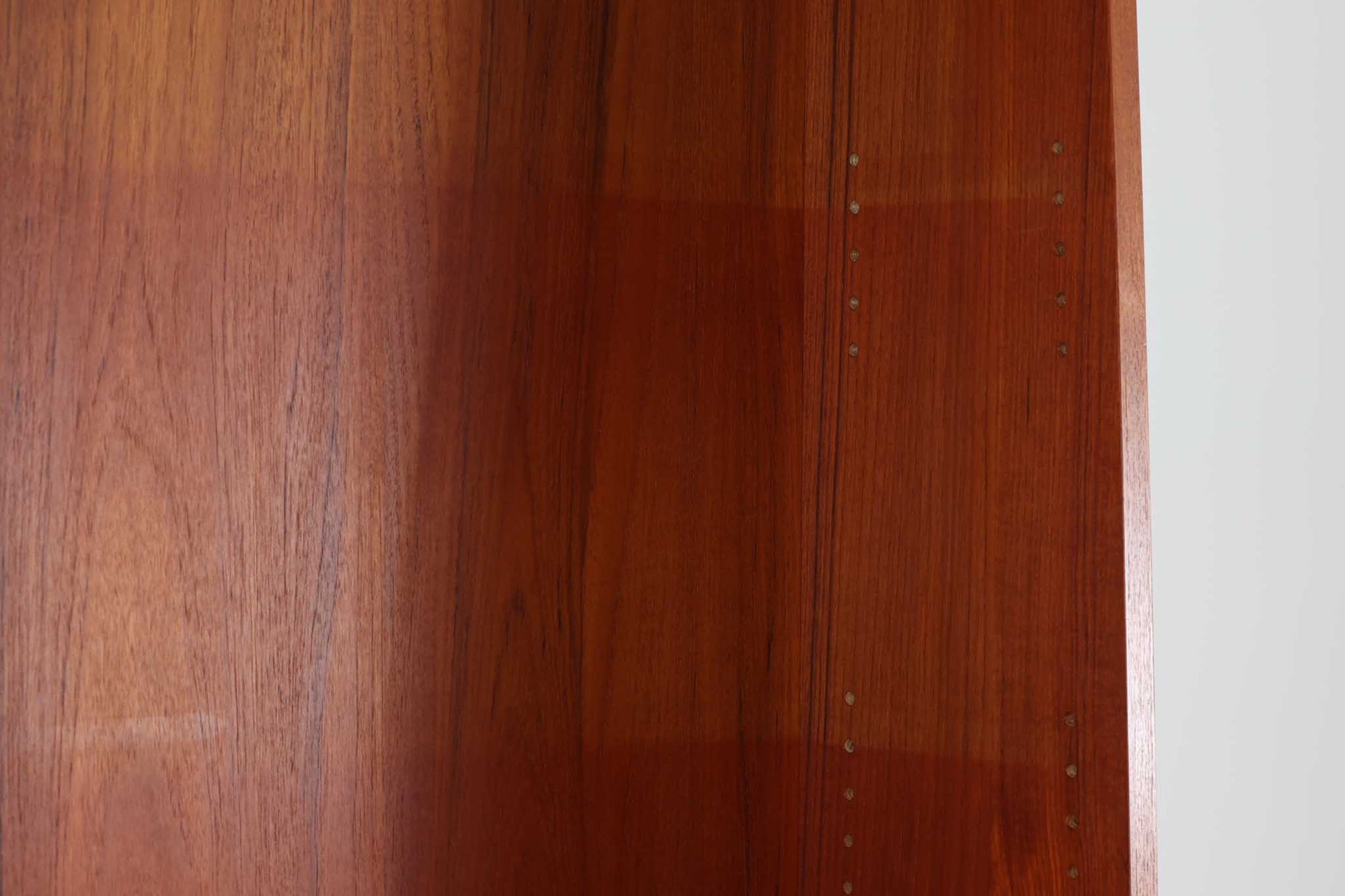 デンマークのデザイナーJohannes Sorthによるシェルフで、Nexø møbelfabrik社で製造されたヴィンテージアイテムです。中央の蛇腹扉は、収納機能と美しいデザインを兼ね備え、スムーズな開閉が特徴です。高品質なチーク材を使用し、木目が美しく、温かみのある仕上がりです。シンプルで洗練されたこのシェルフは、どんな空間にもエレガントな印象を与えます。北欧デザインの魅力を感じさせる一品です。