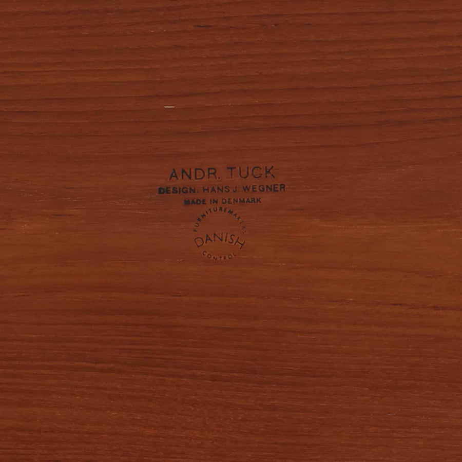 Hans J. Wegnerがデザインし、Andreas Tuck社から発表されたAT33ソーイングテーブルは、チーク無垢材を贅沢に用いた希少なモデルです。両側のバタフライ式天板で作業スペースを拡張でき、仕切り付きの引き出しとラタン製バスケットが裁縫道具や小物を美しく収納します。下段の棚板も備えた実用性の高い構造で、繊細な造作と職人技が光る北欧ビンテージ家具の逸品です。