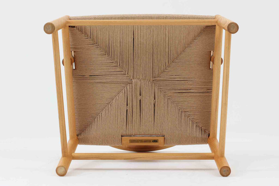 デンマークの巨匠 ハンス・J・ウェグナー によってデザインされた「PP66 Chinese Chair」は、中国の伝統的な椅子にインスピレーションを得たエレガントなデザインが特徴です。優美なカーブを描く背もたれとアームは、美しさと快適さを兼ね備え、身体を包み込むような心地よい座り心地を提供します。熟練の職人によって丁寧に仕上げられたフレームは、滑らかなラインと精巧なジョイントが際立ち、デザインとクラフトマンシップの高さを感じさせます。座面にはナチュラルなペーパーコードを採用し、しなやかで耐久性に優れた快適な座り心地を実現。ウェグナー の作品の中でも比較的新しい1989年のデザインであり、シンプルながらも存在感のある佇まいは、ダイニングチェアとしてはもちろん、書斎やリビングのアクセントとしても最適です。現在も製造されており、現行品の販売価格は約90～100万円程度となっています。
