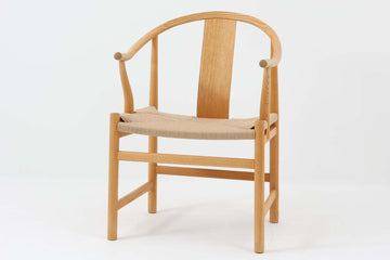 デンマークの巨匠 ハンス・J・ウェグナー によってデザインされた「PP66 Chinese Chair」は、中国の伝統的な椅子にインスピレーションを得たエレガントなデザインが特徴です。優美なカーブを描く背もたれとアームは、美しさと快適さを兼ね備え、身体を包み込むような心地よい座り心地を提供します。熟練の職人によって丁寧に仕上げられたフレームは、滑らかなラインと精巧なジョイントが際立ち、デザインとクラフトマンシップの高さを感じさせます。座面にはナチュラルなペーパーコードを採用し、しなやかで耐久性に優れた快適な座り心地を実現。ウェグナー の作品の中でも比較的新しい1989年のデザインであり、シンプルながらも存在感のある佇まいは、ダイニングチェアとしてはもちろん、書斎やリビングのアクセントとしても最適です。現在も製造されており、現行品の販売価格は約90～100万円程度となっています。