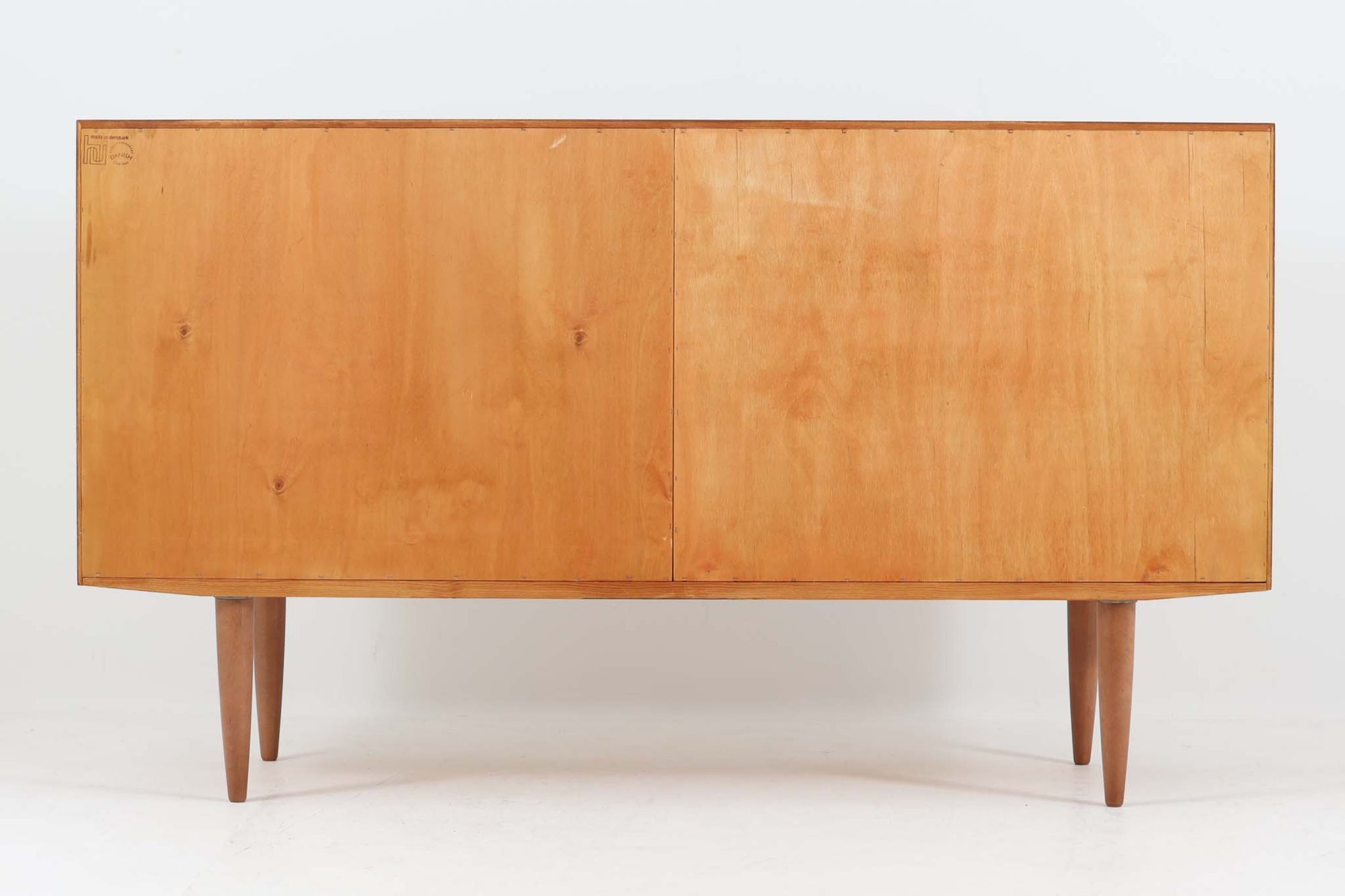 デンマークの家具メーカーHundevad &amp; Co（ハンデバッド）による、Poul Hundevad（ポール・ハンデバッド）デザインのビンテージキャビネットです。美しい木目のチーク材が贅沢に使用され、北欧らしいシンプルで洗練された印象を与えます。両開きの扉内には左側に浅いトレイ状の引き出しが4段、右側には可動棚が2枚設けられており、機能性と収納力に優れた設計。扉の錠前は破損していたため施錠は出来ません。扉の開閉はボールキャッチ方式となっております。鍵は扉開閉用の取っ手として使用します。脚部にはすっきりとしたテーパードレッグが採用され、軽やかで洗練された佇まいが魅力です。リビングやダイニングなど幅広い空間で活躍する一台です。