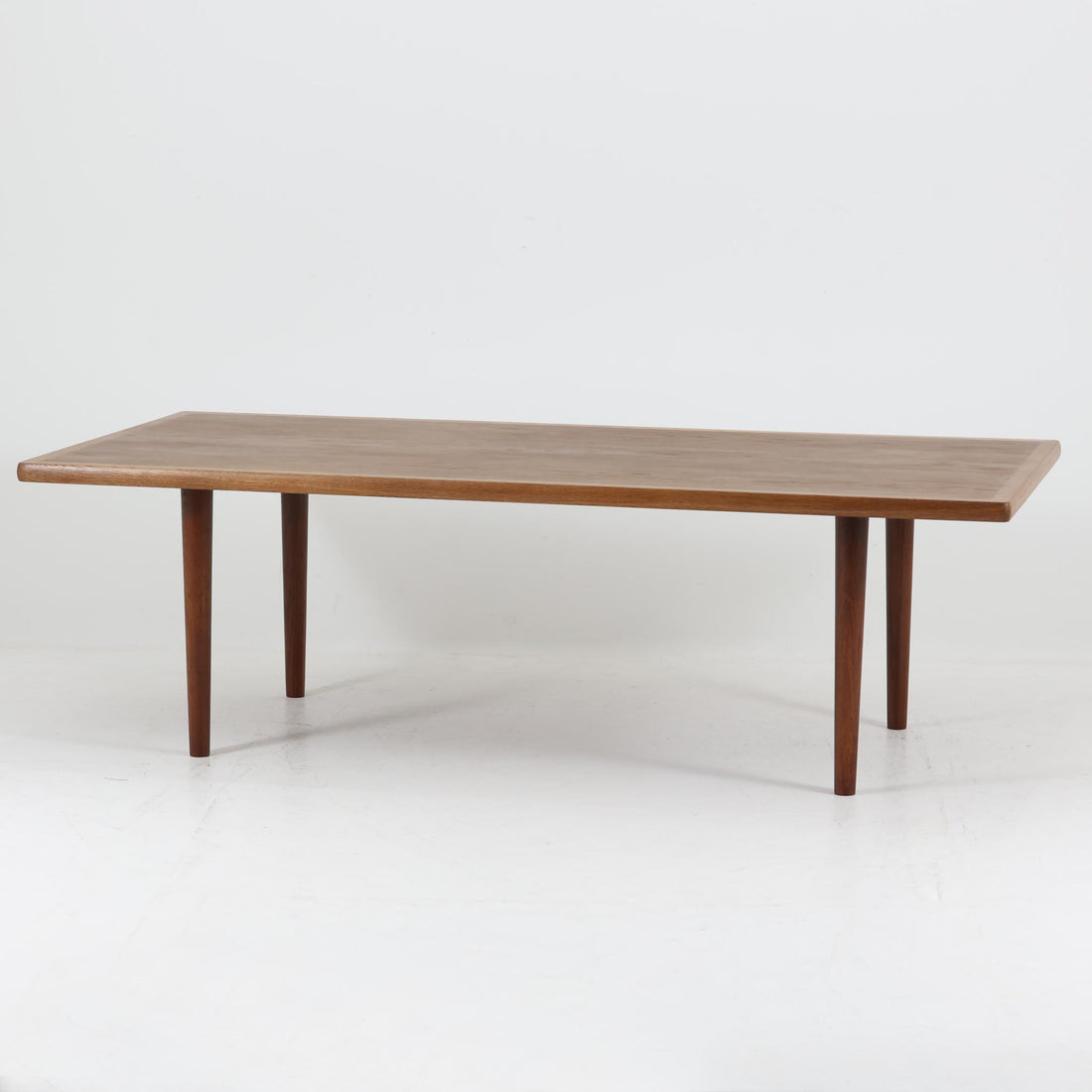 Hans J. Wegnerがデザインし、Getama社より製造されたこちらのセンターテーブルは、幅170cmのゆったりとしたサイズ感と、直線的でシンプルなフォルムが特徴の北欧ビンテージ家具です。ダークオーク材の深みある木目と温かな色調が空間に落ち着きを与え、テーパー状の脚部が軽やかな印象を演出します。リビングでのメインテーブルとしてはもちろん、ソファ前のゆったりとした空間演出にも最適で、年月を経て味わいを増した存在感を楽しめる逸品です。
