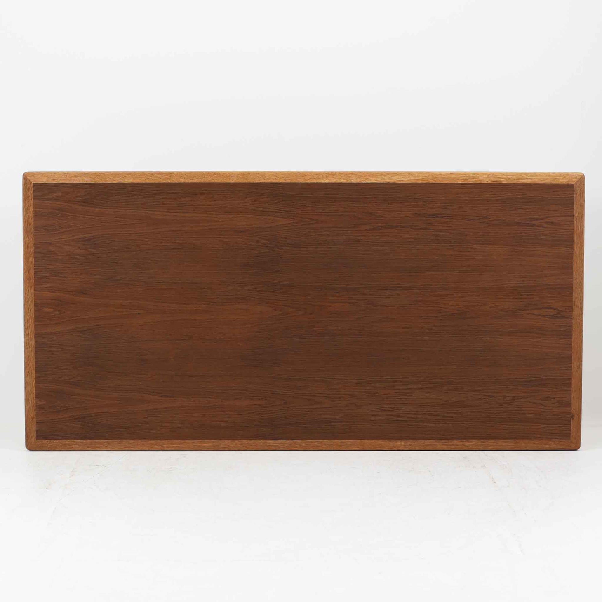 Hans J. Wegnerがデザインし、Getama社より製造されたこちらのセンターテーブルは、幅170cmのゆったりとしたサイズ感と、直線的でシンプルなフォルムが特徴の北欧ビンテージ家具です。ダークオーク材の深みある木目と温かな色調が空間に落ち着きを与え、テーパー状の脚部が軽やかな印象を演出します。リビングでのメインテーブルとしてはもちろん、ソファ前のゆったりとした空間演出にも最適で、年月を経て味わいを増した存在感を楽しめる逸品です。