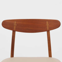 Hans J. Wegnerがデザインし、Carl Hansen & Son社によって製造されたCH30は、チーク材とオーク材を組み合わせた北欧ビンテージらしい温もりある佇まいと、背もたれに施されたフィンガージョイントがアクセントとなる美しいダイニングチェアです。丸みを帯びた背もたれと座面の柔らかなフォルムが身体に心地よくフィットし、長時間の着座でも快適な座り心地を提供します。座面はアイボリー系の合皮で張替済み、実用性と清潔感を兼ね備えており、日常使いから来客用まで幅広いシーンで活躍します。