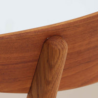 Hans J. Wegnerがデザインし、Carl Hansen & Son社によって製造されたCH30は、チーク材とオーク材を組み合わせた北欧ビンテージらしい温もりある佇まいと、背もたれに施されたフィンガージョイントがアクセントとなる美しいダイニングチェアです。丸みを帯びた背もたれと座面の柔らかなフォルムが身体に心地よくフィットし、長時間の着座でも快適な座り心地を提供します。座面はアイボリー系の合皮で張替済み、実用性と清潔感を兼ね備えており、日常使いから来客用まで幅広いシーンで活躍します。