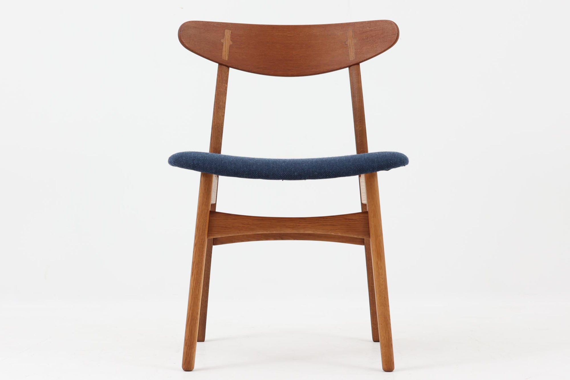 CH30は、ハンス・J・ウェグナーがデザインし、Carl Hansen & Son社によって製造された名作ダイニングチェア。チーク材とオーク材を組み合わせた美しいコントラストが特徴で、木の温もりと洗練されたフォルムが魅力です。特に背もたれと後ろ脚の繋ぎ目は、そのデザインの特徴となっており、独自性とクラフトマンシップの見本と言えるでしょう。背もたれにチーク材が使用された希少なモデルです。人気のため現在復刻されましたが、チーク材とオーク材の組み合わせはビンテージ品でのみ入手可能です。
