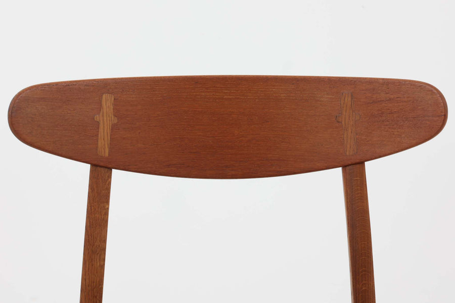 CH30は、ハンス・J・ウェグナーがデザインし、Carl Hansen & Son社によって製造された名作ダイニングチェア。チーク材とオーク材を組み合わせた美しいコントラストが特徴で、木の温もりと洗練されたフォルムが魅力です。特に背もたれと後ろ脚の繋ぎ目は、そのデザインの特徴となっており、独自性とクラフトマンシップの見本と言えるでしょう。背もたれにチーク材が使用された希少なモデルです。人気のため現在復刻されましたが、チーク材とオーク材の組み合わせはビンテージ品でのみ入手可能です。