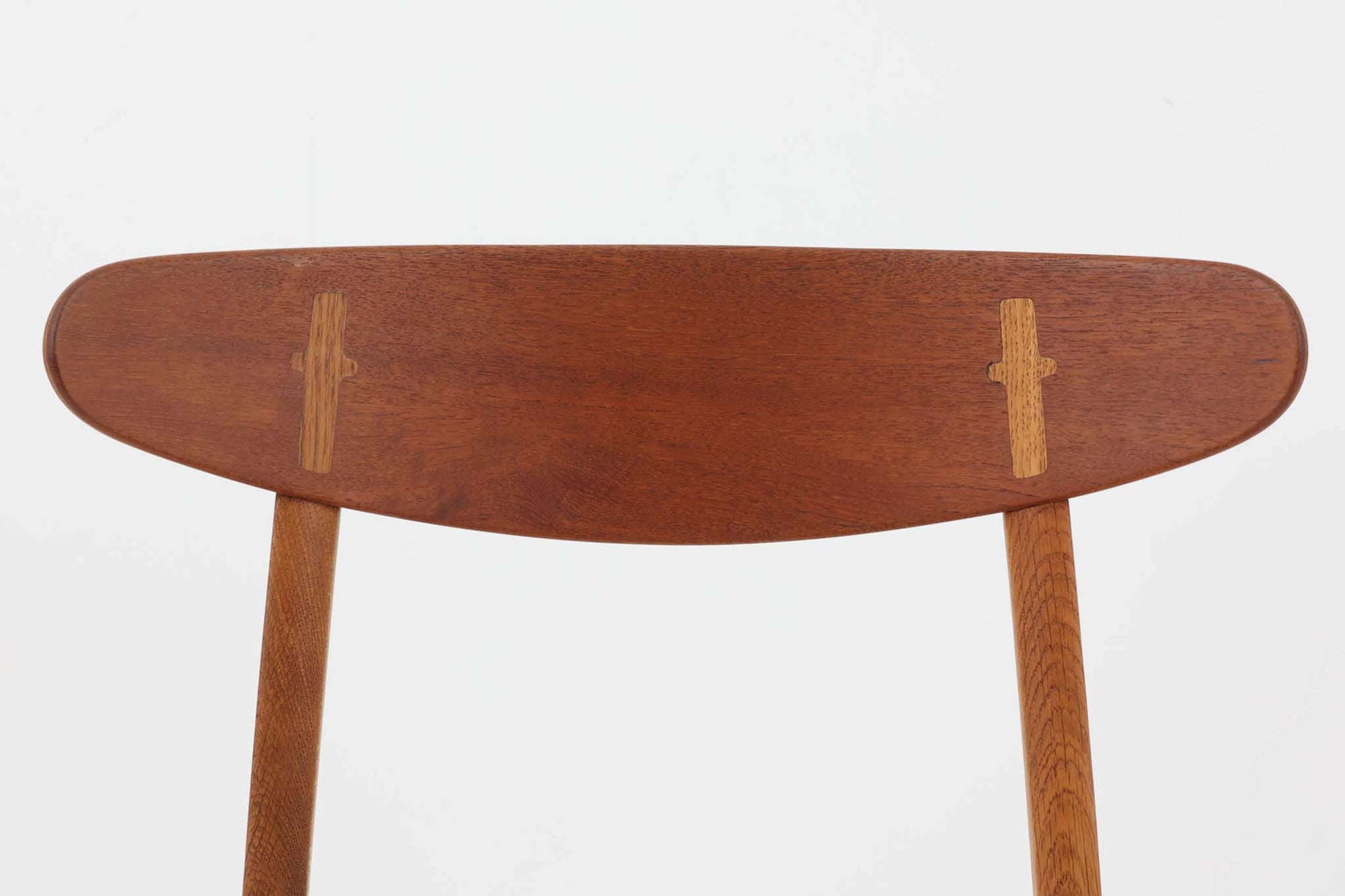 CH30は、ハンス・J・ウェグナーがデザインし、Carl Hansen &amp; Son社によって製造された名作ダイニングチェア。チーク材とオーク材を組み合わせた美しいコントラストが特徴で、木の温もりと洗練されたフォルムが魅力です。特に背もたれと後ろ脚の繋ぎ目は、そのデザインの特徴となっており、独自性とクラフトマンシップの見本と言えるでしょう。背もたれにチーク材が使用された希少なモデルです。人気のため現在復刻されましたが、チーク材とオーク材の組み合わせはビンテージ品でのみ入手可能です。