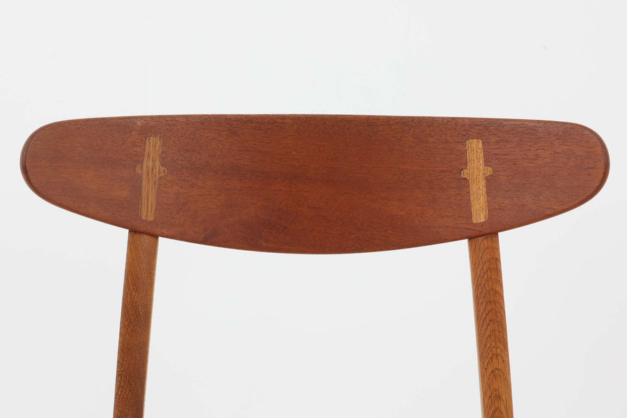CH30は、ハンス・J・ウェグナーがデザインし、Carl Hansen & Son社によって製造された名作ダイニングチェア。チーク材とオーク材を組み合わせた美しいコントラストが特徴で、木の温もりと洗練されたフォルムが魅力です。特に背もたれと後ろ脚の繋ぎ目は、そのデザインの特徴となっており、独自性とクラフトマンシップの見本と言えるでしょう。背もたれにチーク材が使用された希少なモデルです。人気のため現在復刻されましたが、チーク材とオーク材の組み合わせはビンテージ品でのみ入手可能です。