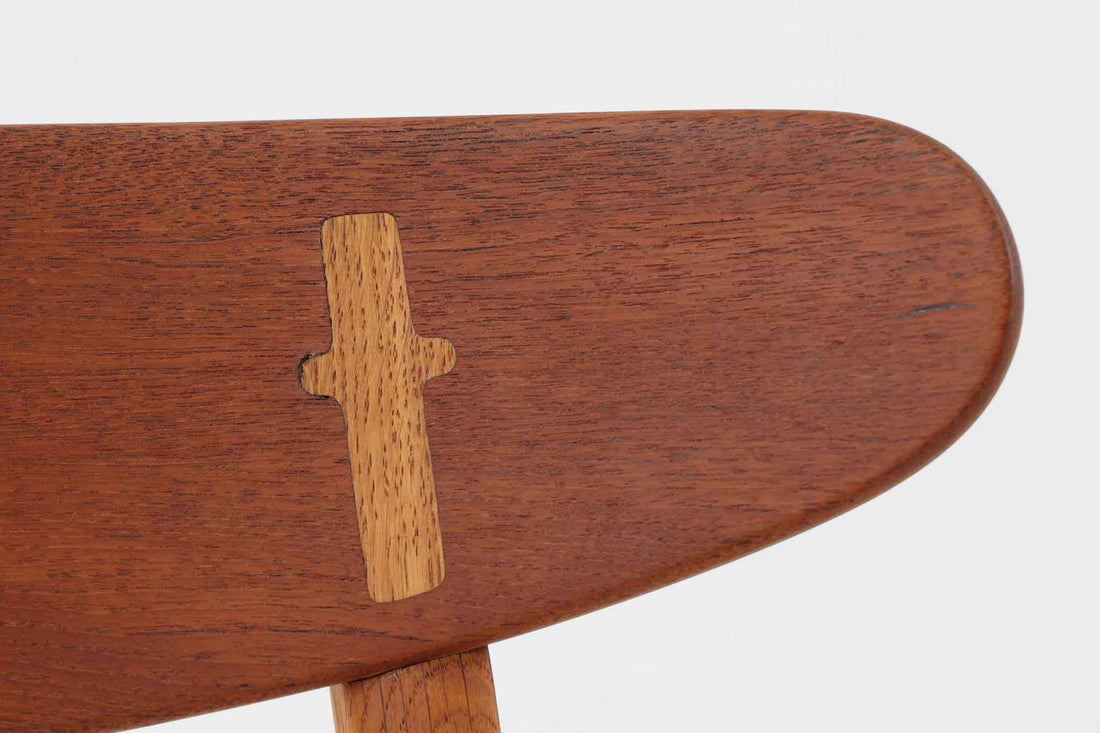CH30は、ハンス・J・ウェグナーがデザインし、Carl Hansen & Son社によって製造された名作ダイニングチェア。チーク材とオーク材を組み合わせた美しいコントラストが特徴で、木の温もりと洗練されたフォルムが魅力です。特に背もたれと後ろ脚の繋ぎ目は、そのデザインの特徴となっており、独自性とクラフトマンシップの見本と言えるでしょう。背もたれにチーク材が使用された希少なモデルです。人気のため現在復刻されましたが、チーク材とオーク材の組み合わせはビンテージ品でのみ入手可能です。