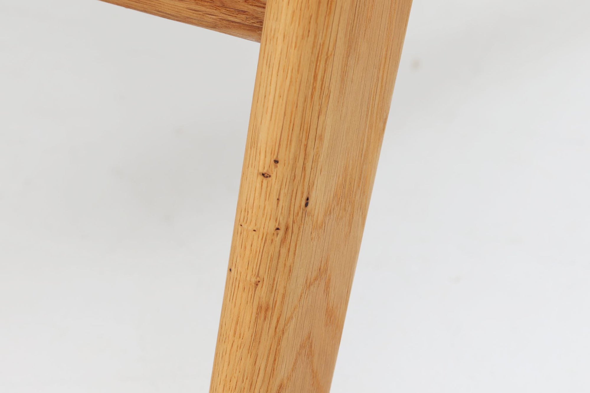 デンマークの国民的ブランドFDBによるビンテージのイージーチェア「J53」。デザイナーは北欧モダンデザインの旗手、Poul m. Volther（ポール・m・ヴォルター）。J53は同氏が手掛けたJシリーズの中でも希少なラウンジチェアタイプで、ゆったりとした座り心地とシンプルな構造美が魅力です。フレームには美しい木目を持つオーク材が使用されており、ナチュラルな風合いが北欧らしい温もりを感じさせます。背面の縦格子デザインや、柔らかくカーブしたアームの形状にも同氏ならではのディテールが感じられます。クッションは新たに張り替え済みで、清潔感のあるアイボリー系のファブリックが品のある印象を与えます。背面に「mADE IN DENmARK」およびFDBの刻印あり。