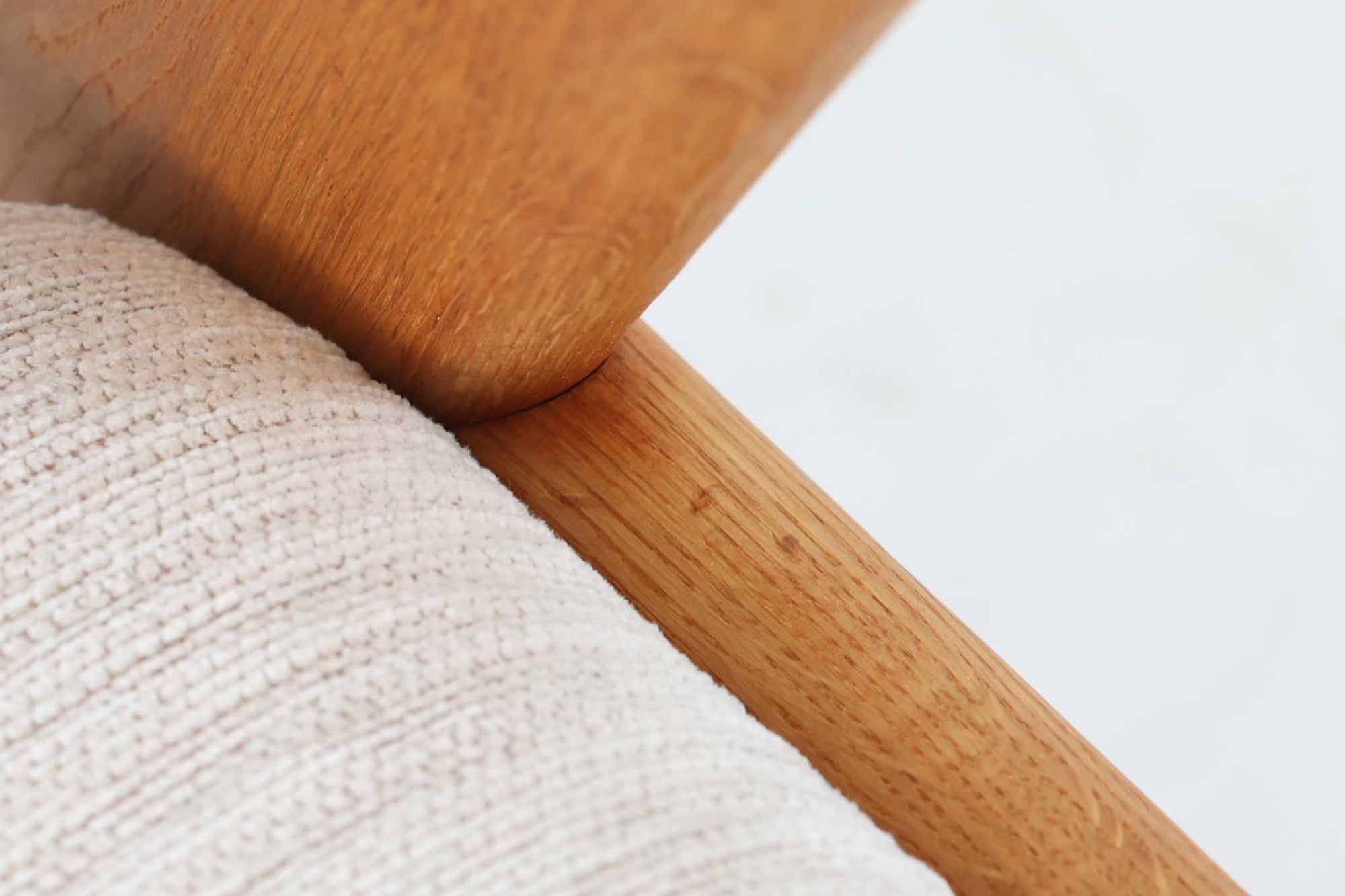 デンマークの国民的ブランドFDBによるビンテージのイージーチェア「J53」。デザイナーは北欧モダンデザインの旗手、Poul m. Volther（ポール・m・ヴォルター）。J53は同氏が手掛けたJシリーズの中でも希少なラウンジチェアタイプで、ゆったりとした座り心地とシンプルな構造美が魅力です。フレームには美しい木目を持つオーク材が使用されており、ナチュラルな風合いが北欧らしい温もりを感じさせます。背面の縦格子デザインや、柔らかくカーブしたアームの形状にも同氏ならではのディテールが感じられます。クッションは新たに張り替え済みで、清潔感のあるアイボリー系のファブリックが品のある印象を与えます。背面に「mADE IN DENmARK」およびFDBの刻印あり。