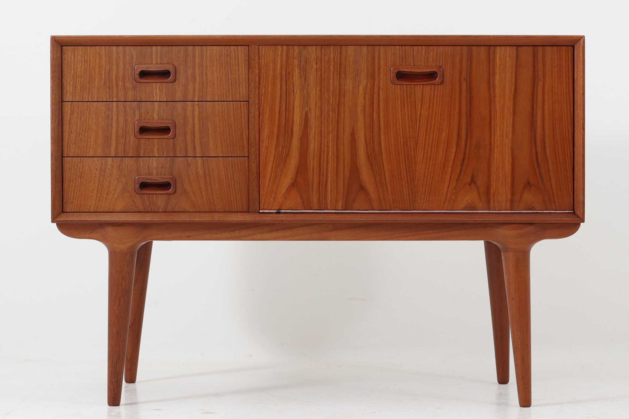 北欧より買い付けたローボードです。Gunni Omannのデザインの中でも、特に小ぶりなローボードは非常に希少で、現地でもなかなか見かけることはありません。幅85cmとコンパクトながら、引き出しが3杯、さらにドロップダウン式の開き戸も備えており、機能性に優れています。脚のデザインもGunni Omannならではの特徴的なもので、クオリティーの高い作品です。良質なチーク材が使用されており、経年によって変化した色味が魅力的です。