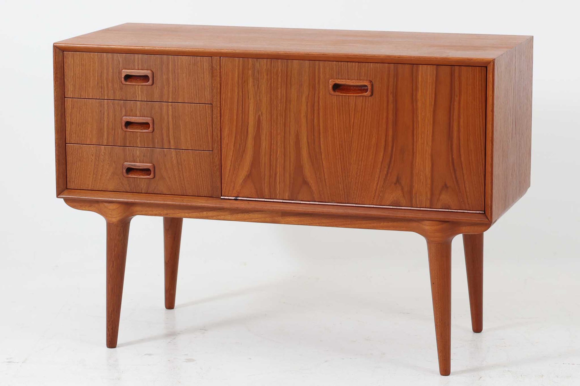 北欧より買い付けたローボードです。Gunni Omannのデザインの中でも、特に小ぶりなローボードは非常に希少で、現地でもなかなか見かけることはありません。幅85cmとコンパクトながら、引き出しが3杯、さらにドロップダウン式の開き戸も備えており、機能性に優れています。脚のデザインもGunni Omannならではの特徴的なもので、クオリティーの高い作品です。良質なチーク材が使用されており、経年によって変化した色味が魅力的です。