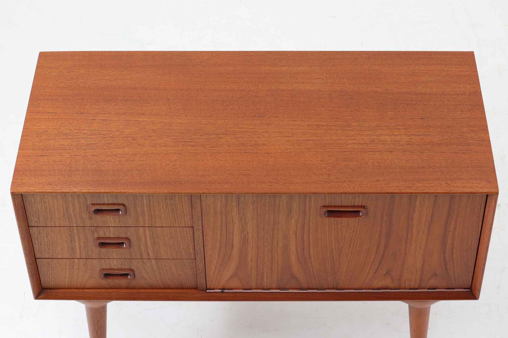 北欧より買い付けたローボードです。Gunni Omannのデザインの中でも、特に小ぶりなローボードは非常に希少で、現地でもなかなか見かけることはありません。幅85cmとコンパクトながら、引き出しが3杯、さらにドロップダウン式の開き戸も備えており、機能性に優れています。脚のデザインもGunni Omannならではの特徴的なもので、クオリティーの高い作品です。良質なチーク材が使用されており、経年によって変化した色味が魅力的です。