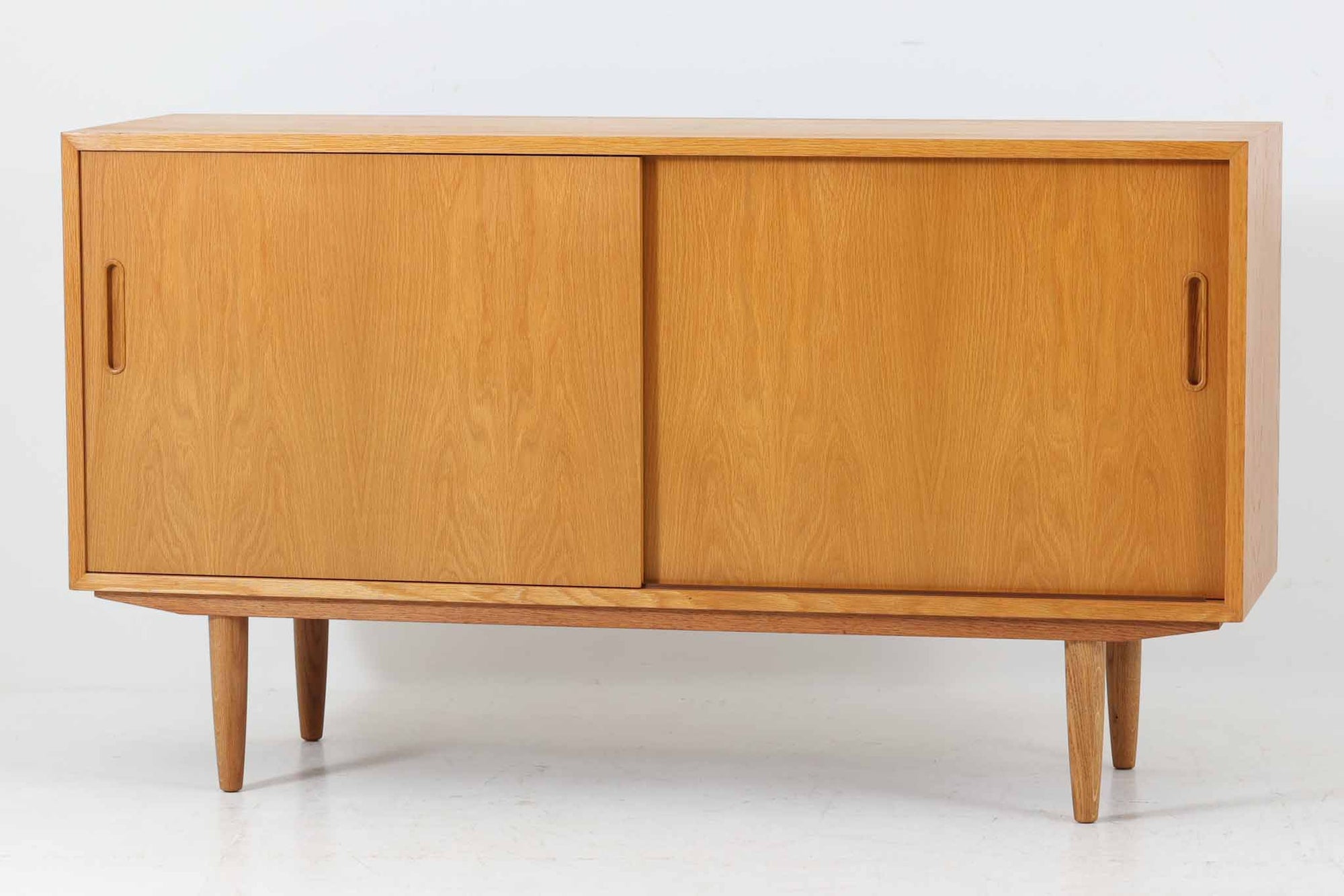 北欧より買い付けたサイドボードです。収納部の右側には、元々レコード収納用として設計されていたと思われる取り外し可能な縦仕切りがあり、幅の調整も可能です。棚板は取り外しできませんが、縦仕切りは全て取り外し可能で、大きなアイテムの収納にも対応できます。左側の収納部には、取り外しや可動が可能な引き出しが2杯備わっており、使い勝手も良好です。シンプルながらも高いクオリティを誇り、デンマークの家具デザイナーPoul Hundevadによってデザインされた本作は、デンマークの厳しい品質基準を満たした「DANISH FURNITUREmAKE'S CONTROL」のロゴシールが付いております。