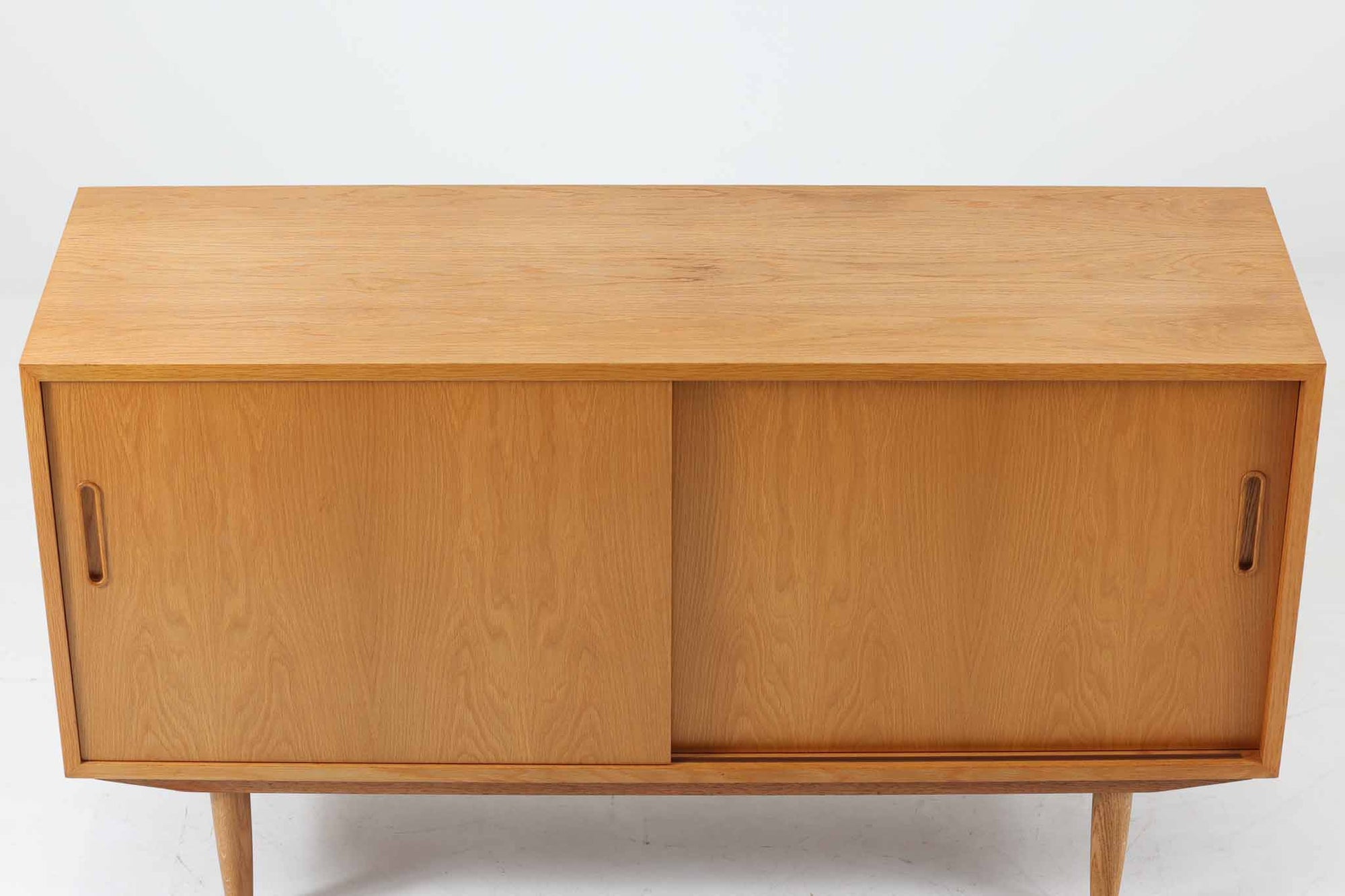 北欧より買い付けたサイドボードです。収納部の右側には、元々レコード収納用として設計されていたと思われる取り外し可能な縦仕切りがあり、幅の調整も可能です。棚板は取り外しできませんが、縦仕切りは全て取り外し可能で、大きなアイテムの収納にも対応できます。左側の収納部には、取り外しや可動が可能な引き出しが2杯備わっており、使い勝手も良好です。シンプルながらも高いクオリティを誇り、デンマークの家具デザイナーPoul Hundevadによってデザインされた本作は、デンマークの厳しい品質基準を満たした「DANISH FURNITUREmAKE'S CONTROL」のロゴシールが付いております。
