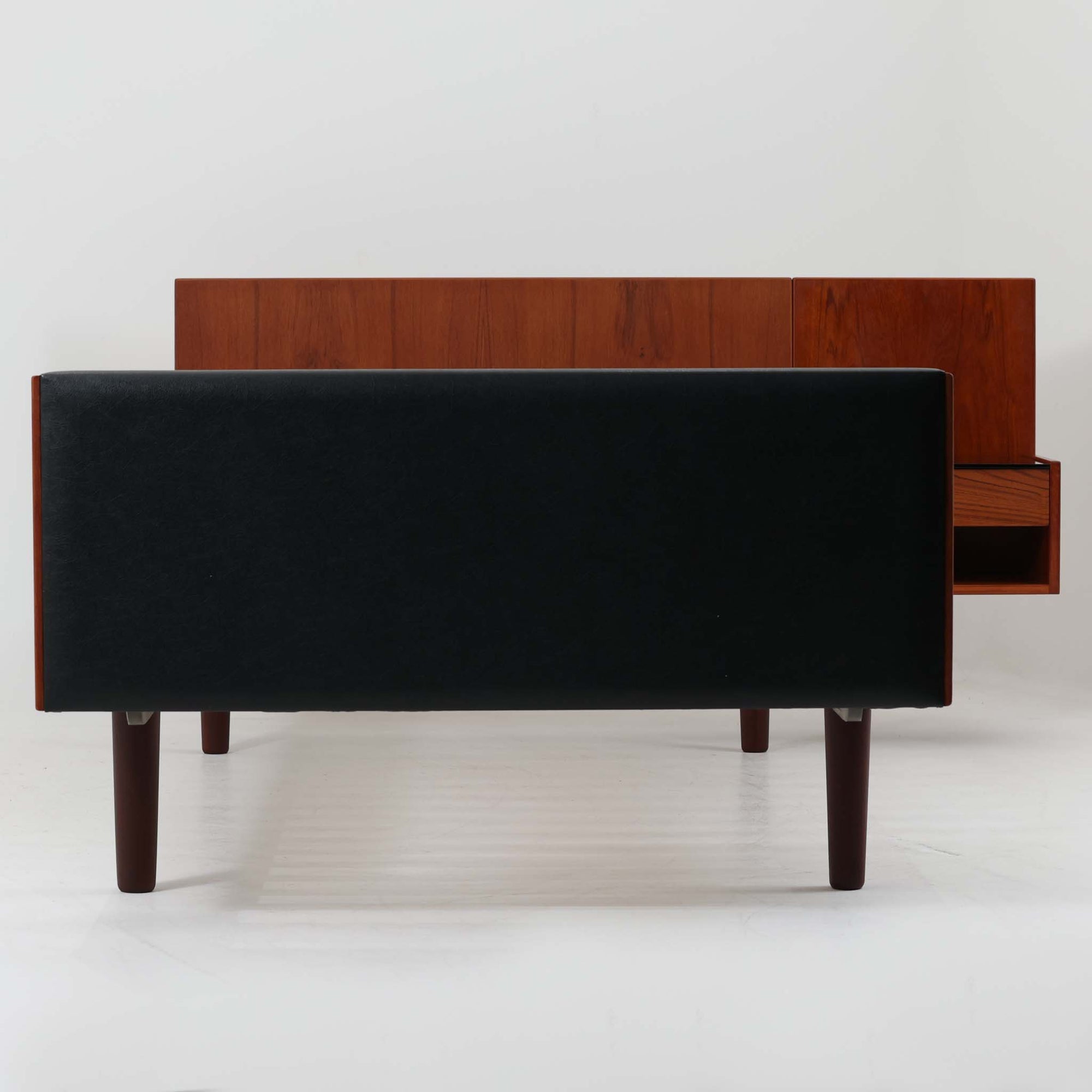 Hans J. Wegnerがデザインし、Getama社によって製造されたこちらのシングルベッドフレームは、チーク材とブラックの合皮パネルが上品に調和した、北欧ビンテージならではの美しい佇まいが魅力です。ヘッドボードにはブラックガラスを載せた引き出し付きのナイトテーブルが備えられていますが、取り外しが可能な構造となっており、空間や用途に応じて柔軟にレイアウトできます。堅牢なスノコ構造で寝具の通気性にも優れ、実用性とデザイン性を兼ね備えた一点です。