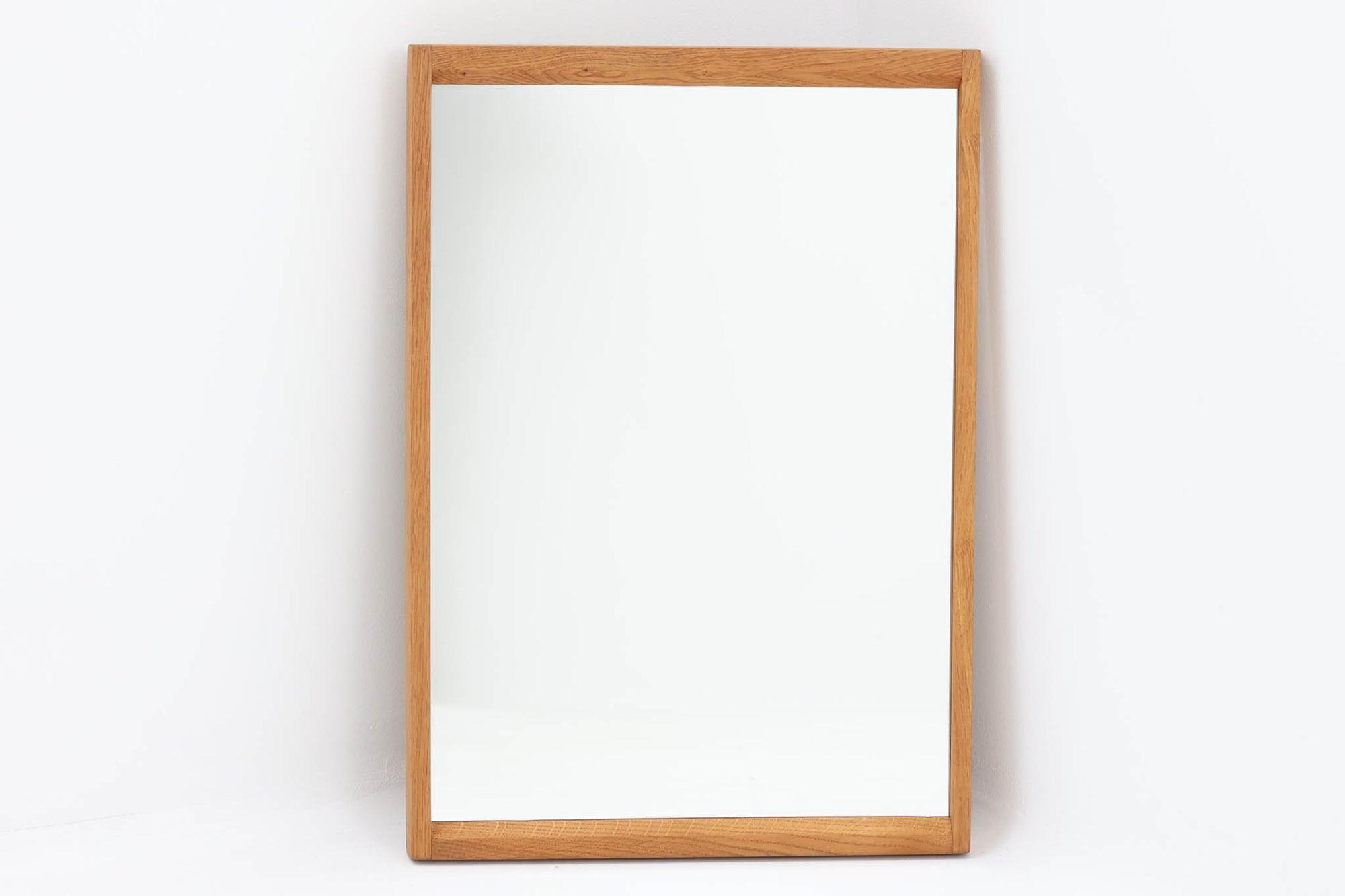 デンマークの家具ブランドAksel Kjersgaard（アクセル・キアスゴー）社製、Kai Kristiansen（カイ・クリスチャンセン）デザインのビンテージミラーです。シンプルで洗練された木製フレームは上質なオーク材で構成され、北欧デザインらしい端正な佇まいが魅力。職人技が光るフィンガージョイントや、背面の刻印からオリジナルであることが確認できます。玄関やリビング、寝室など様々な空間に自然と調和します。ビンテージならではの風合いと高い実用性を兼ね備えた一品です。