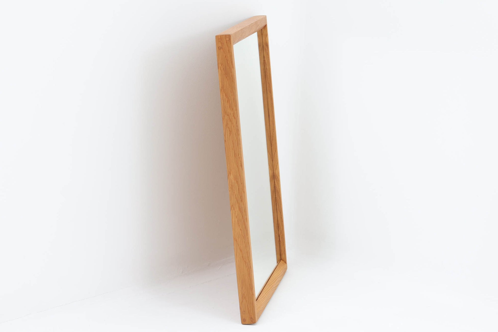 デンマークの家具ブランドAksel Kjersgaard（アクセル・キアスゴー）社製、Kai Kristiansen（カイ・クリスチャンセン）デザインのビンテージミラーです。シンプルで洗練された木製フレームは上質なオーク材で構成され、北欧デザインらしい端正な佇まいが魅力。職人技が光るフィンガージョイントや、背面の刻印からオリジナルであることが確認できます。玄関やリビング、寝室など様々な空間に自然と調和します。ビンテージならではの風合いと高い実用性を兼ね備えた一品です。