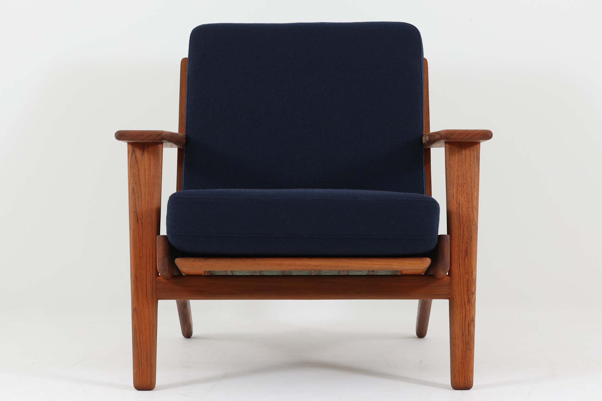 北欧家具を代表するソファ『GE290』です。現在リプロダクト品が販売されていますが、こちらは本物です。元々はベッド会社であるGETAmA社ならではのコイルスプリングが内包されたクッションの座り心地は、弾力があり心地良く、読書や映画などのリラックスタイムに最適です。立ち上がる際も適度なはね返りがあるので、動く時に億劫になる事はありません。Hans J. Wegnerならではの時代を超えた美しいデザインも魅力のひとつ。横や背面から眺めると、また異なる表情が楽しめます。さらに、こちらは現行品では手に入らない希少なチーク材モデル。素材の質感と温かみを存分に味わえる逸品です。